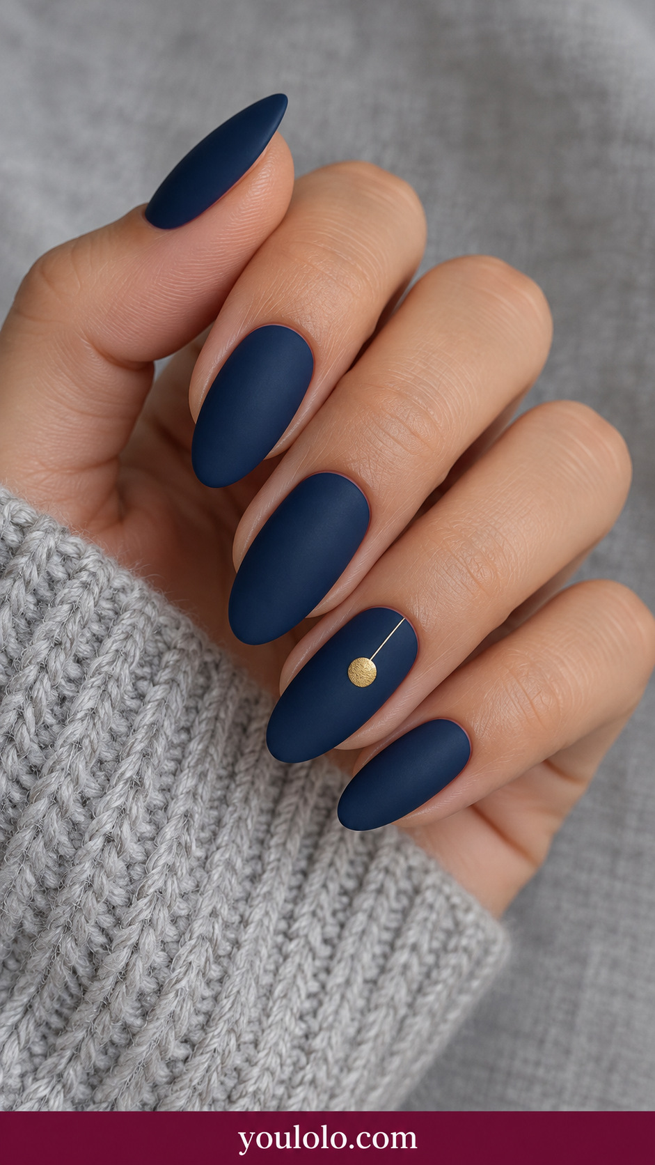 medium almond deep midnight navy nails one tiny flat gold round bauble with fine hanging line on ring nail on a naturally relaxed adult hand