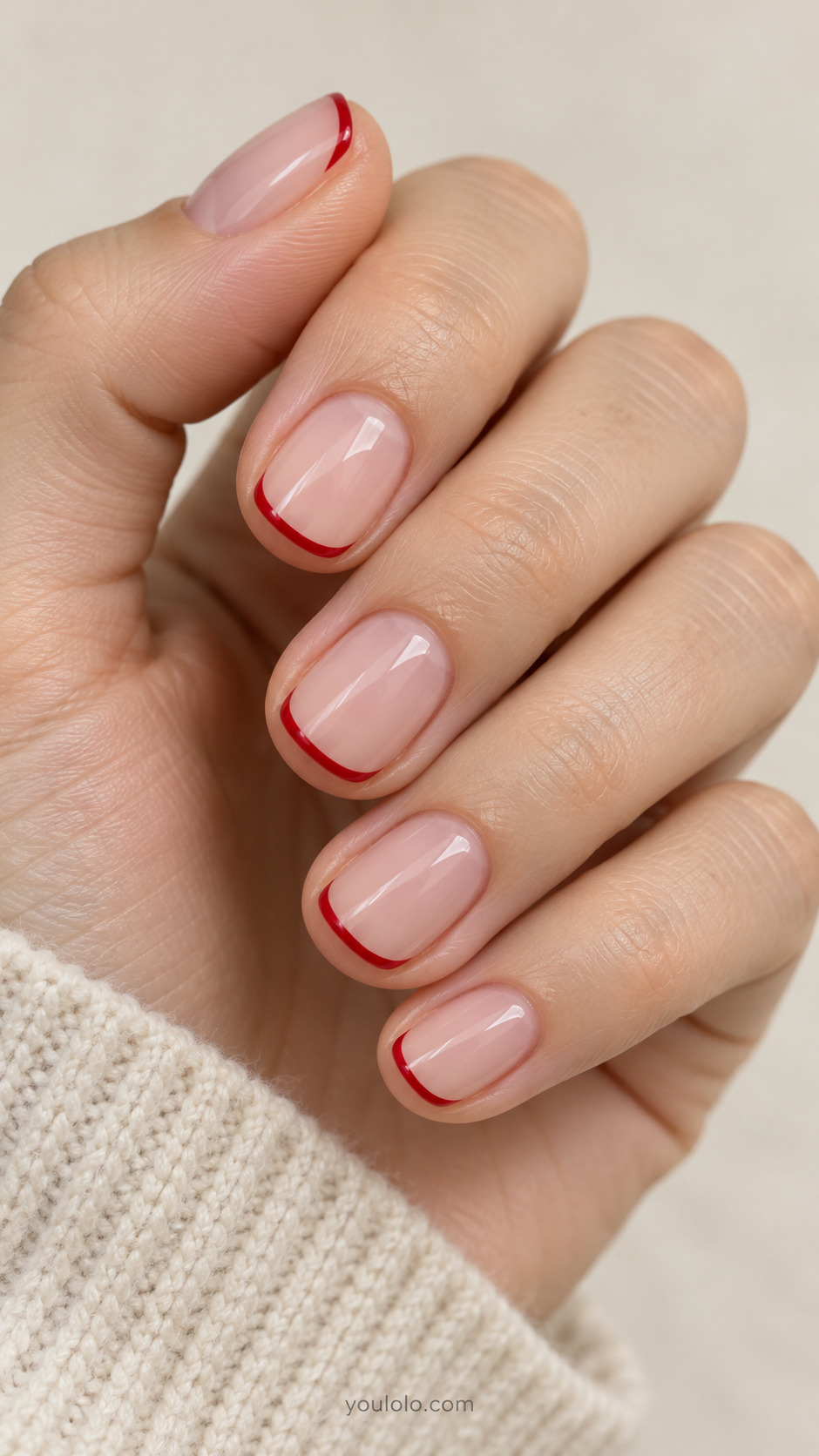 very short squoval nails, translucent neutral pink base, ultra thin cherry-red curved tips on a naturally gathered hand