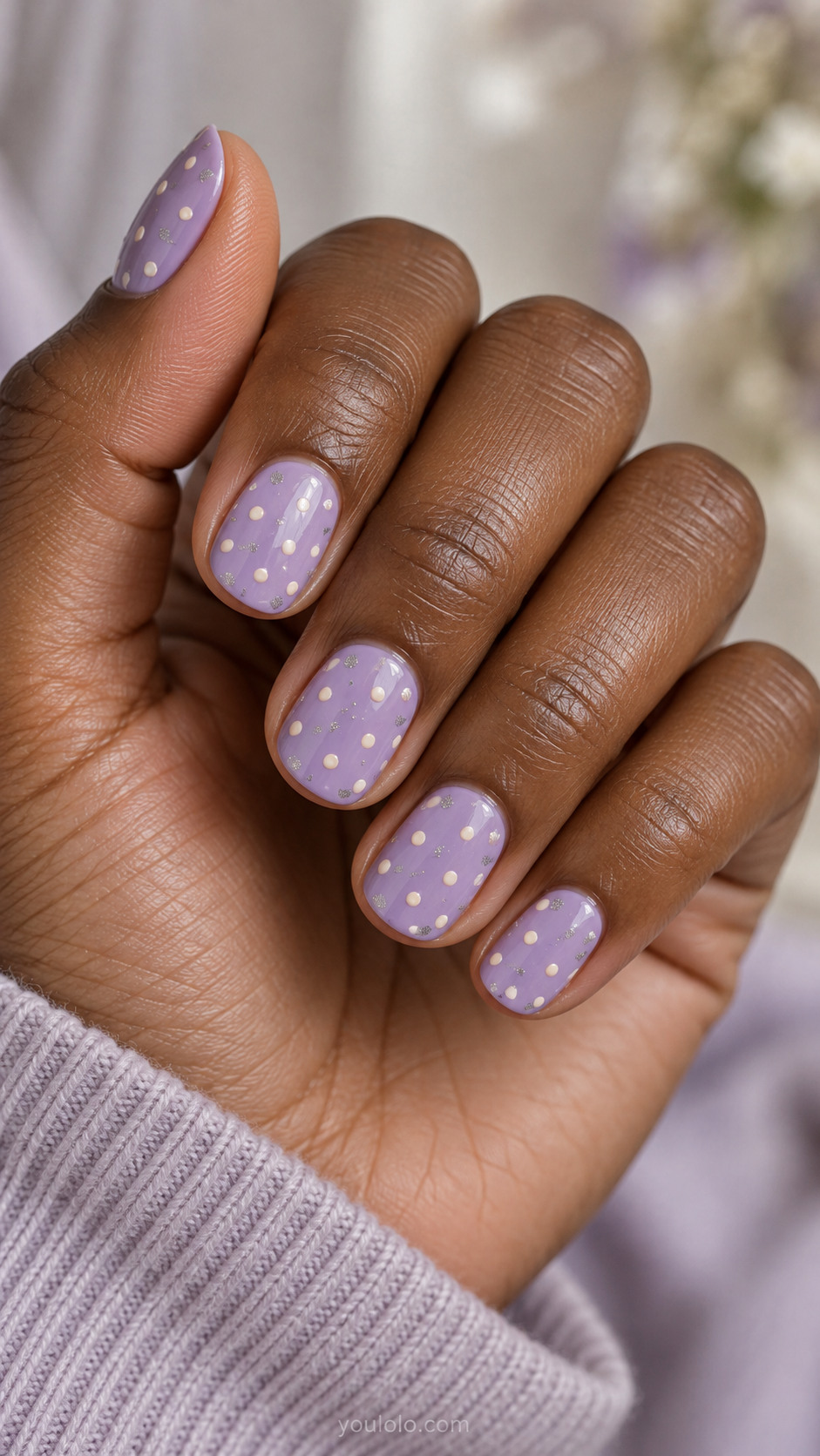 Short lavender nails with ivory dots and small silver shimmer accents.