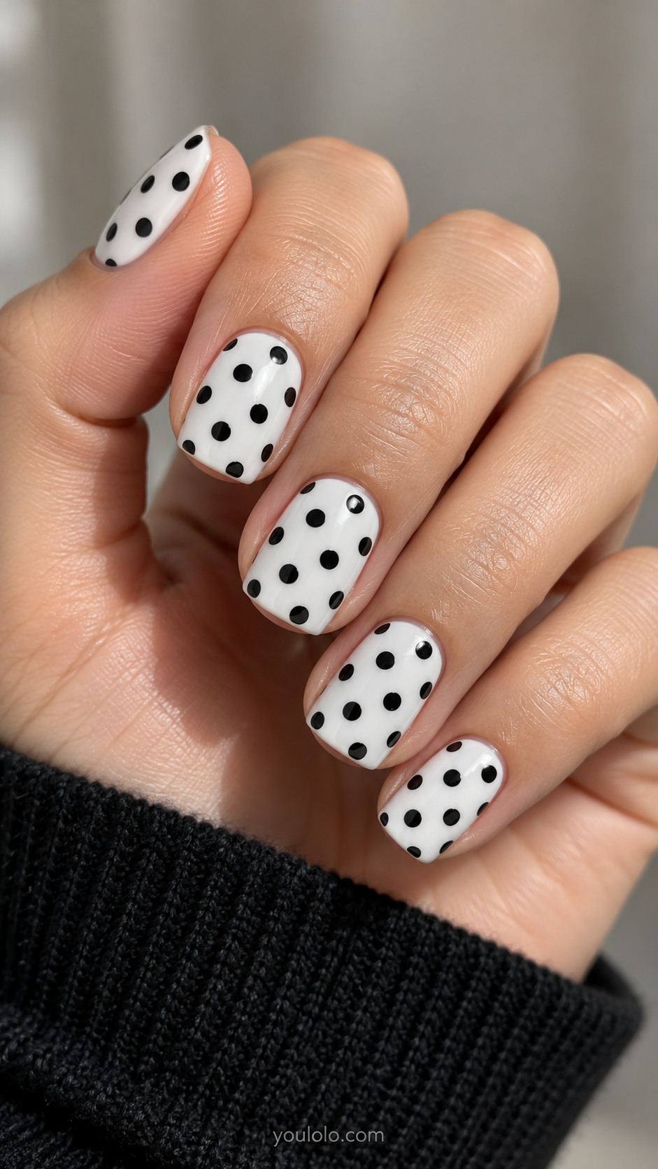 Short squoval white nails with medium black round polka dots in evenly spaced offset rows