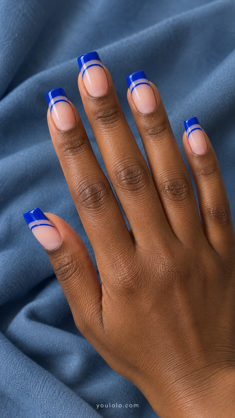 Medium square acrylic extensions sheer pink base with cobalt blue French tips and a separate thin cobalt arc below each tip