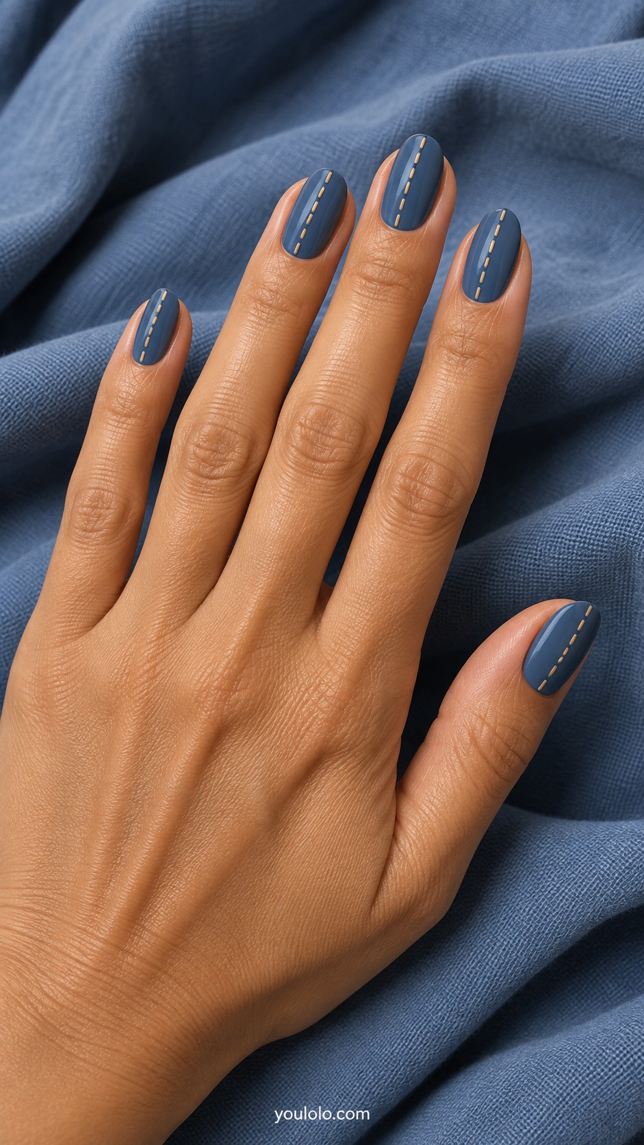 Medium oval nails dusty denim blue with thin tan dashed vertical seam lines