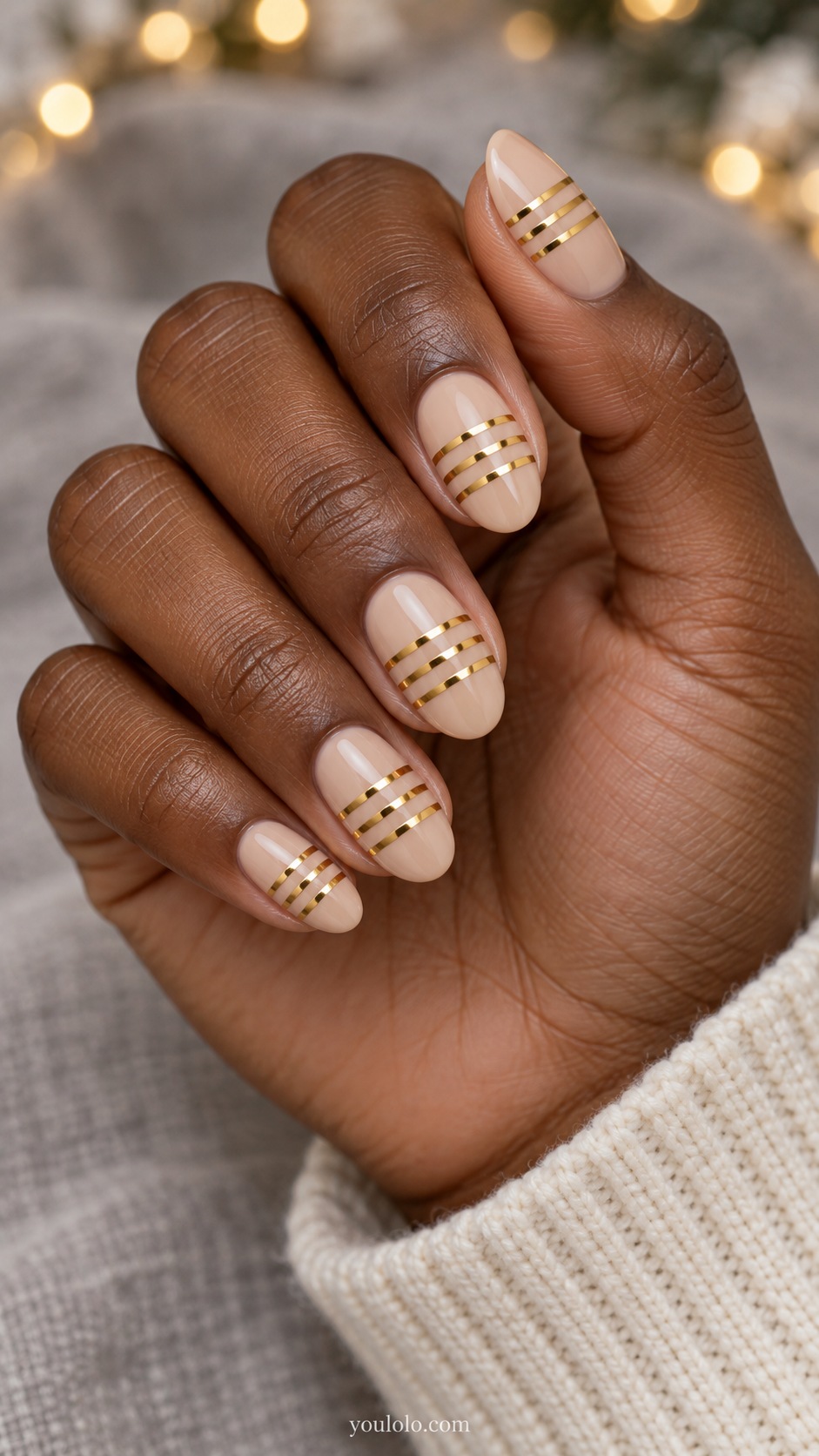 Medium oval nude beige nails three thin parallel gold chrome transverse bands with nude gaps