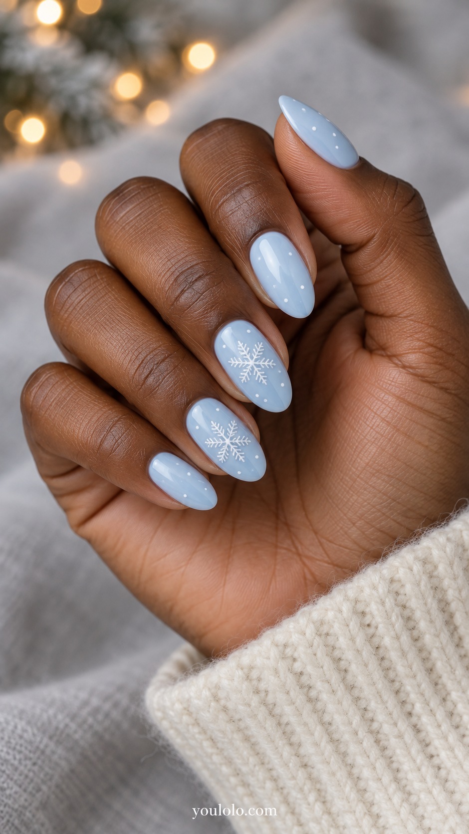 Medium almond pale ice blue nails fine white six branched snowflakes on two nails tiny white dots others