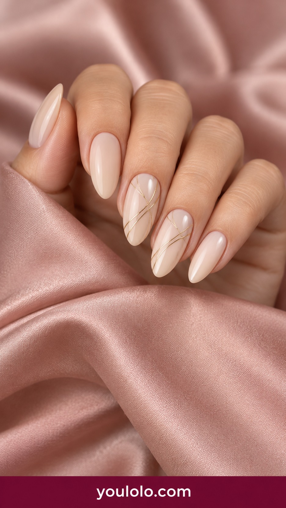 Medium oval warm ivory nails with very fine crossing gold thread lines on two accents on a naturally curled young adult hand