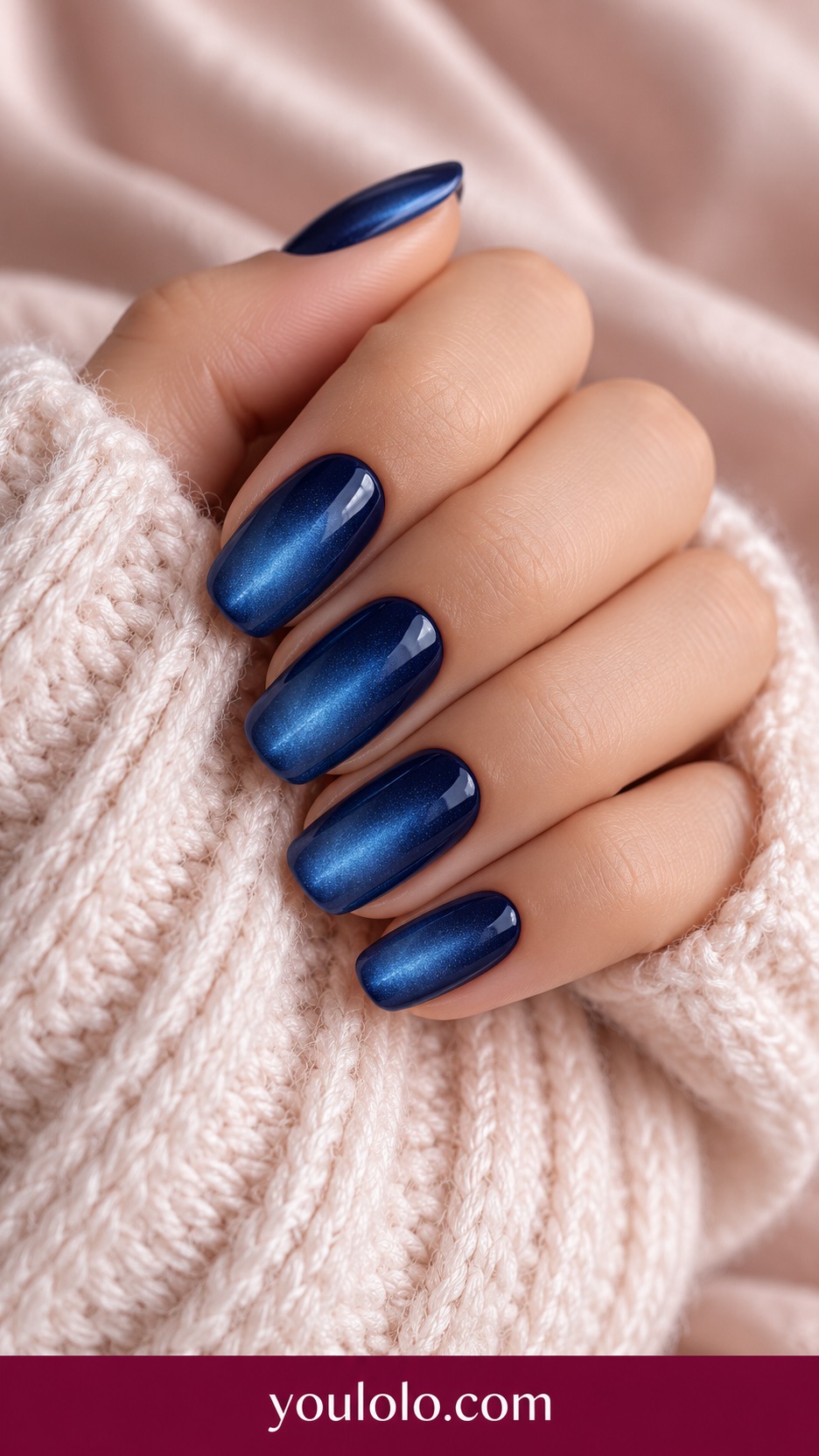 Medium soft square deep navy magnetic nails with broad soft blue satin glow on a naturally curled young adult hand