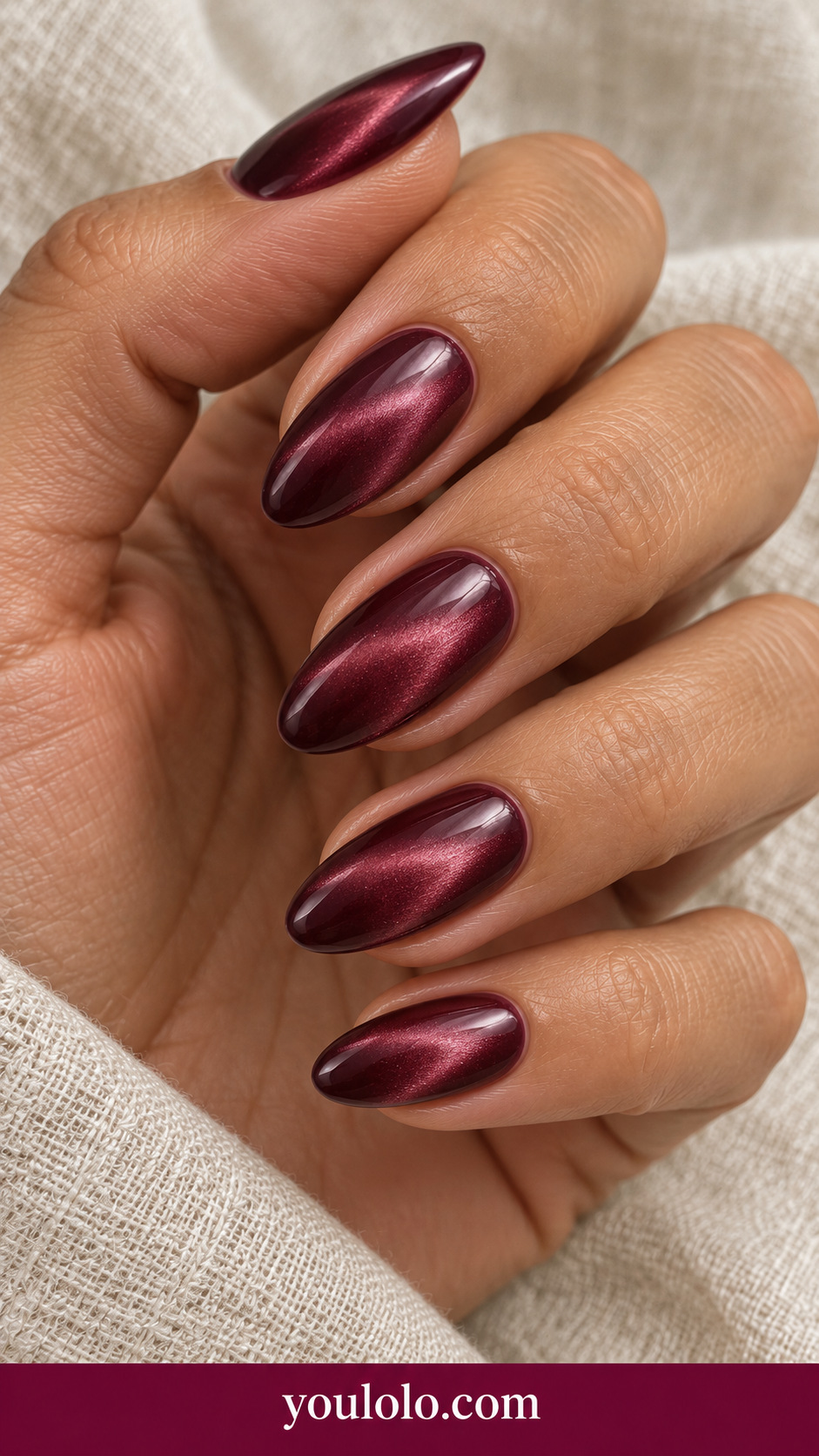 medium almond deep maroon magnetic press-on nails with broad soft wine pink velvet highlight, no decorations on a naturally posed adult female hand