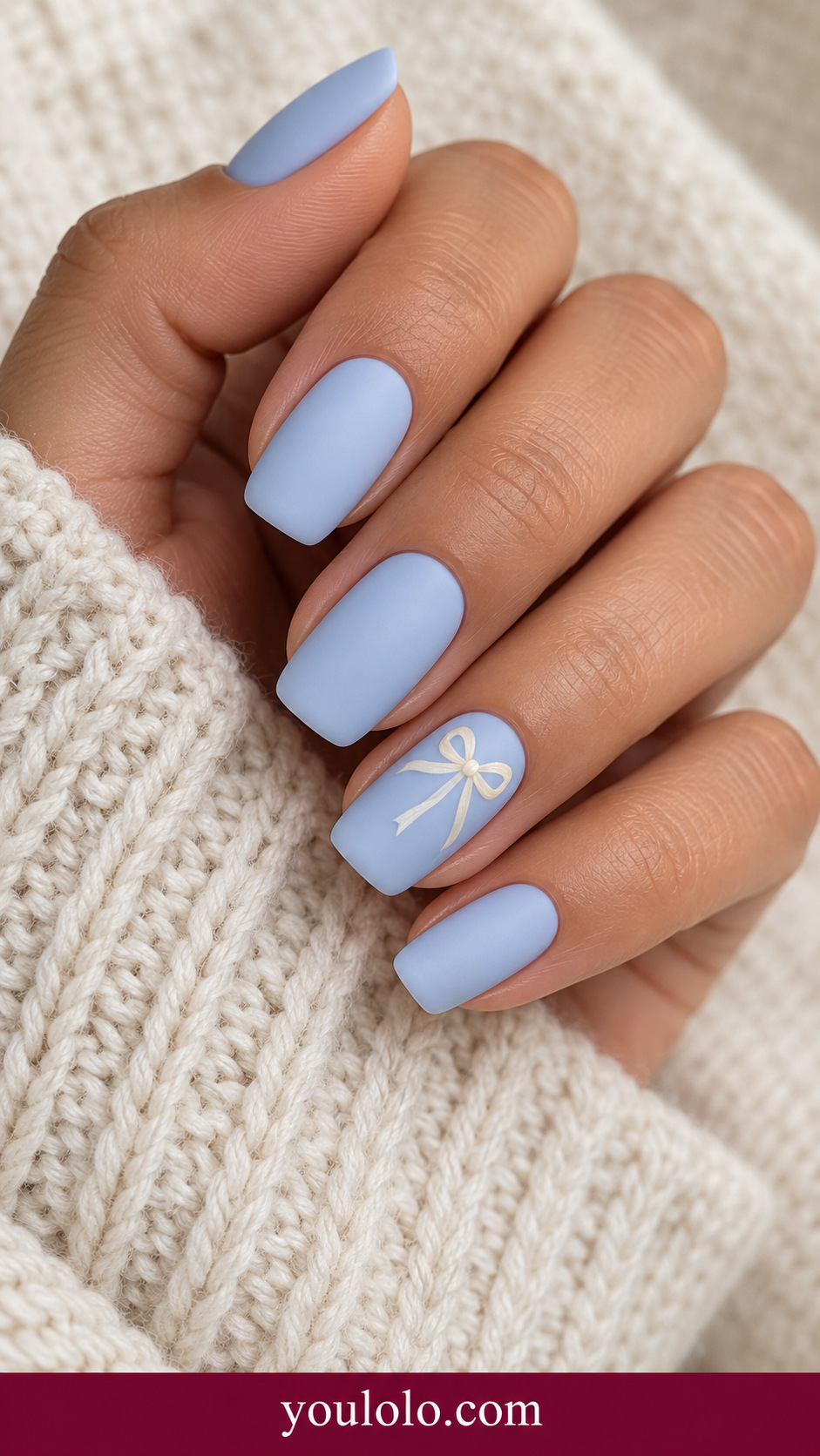 medium soft square powder blue nails one accent miniature flat ivory ribbon bow and fine tails on a naturally relaxed adult hand