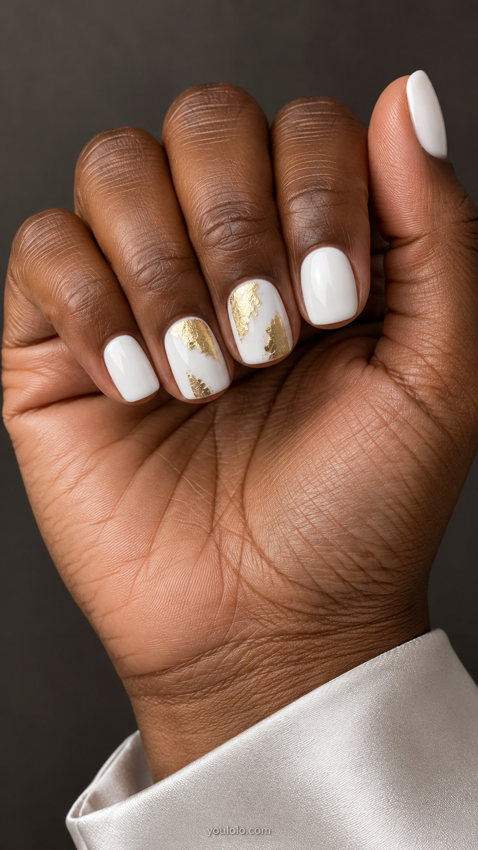 Short squoval nails, opaque white, irregular gold foil fragments on the middle and ring nails