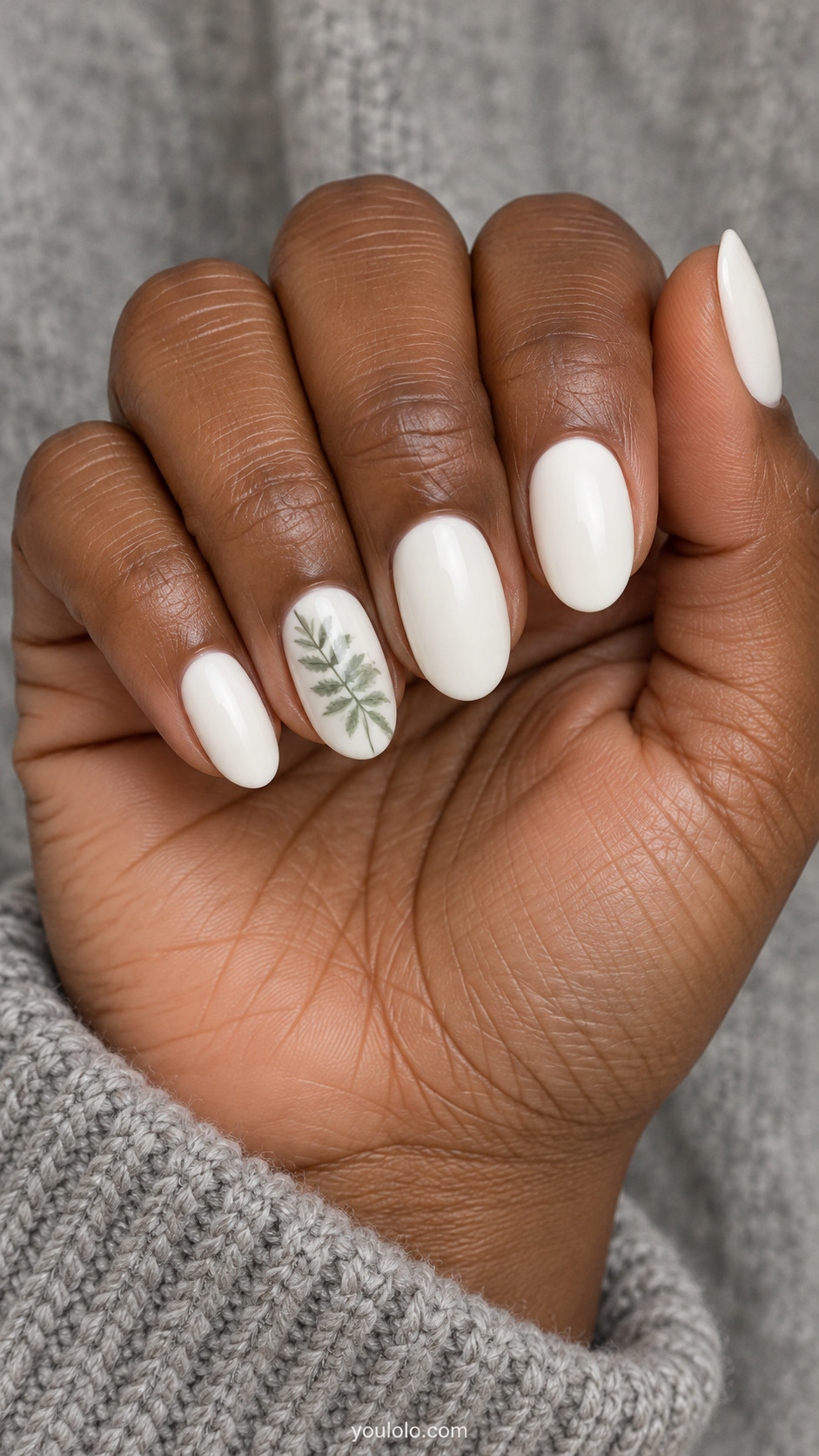 Creamy white oval nails with a sage fern painted on the ring nail