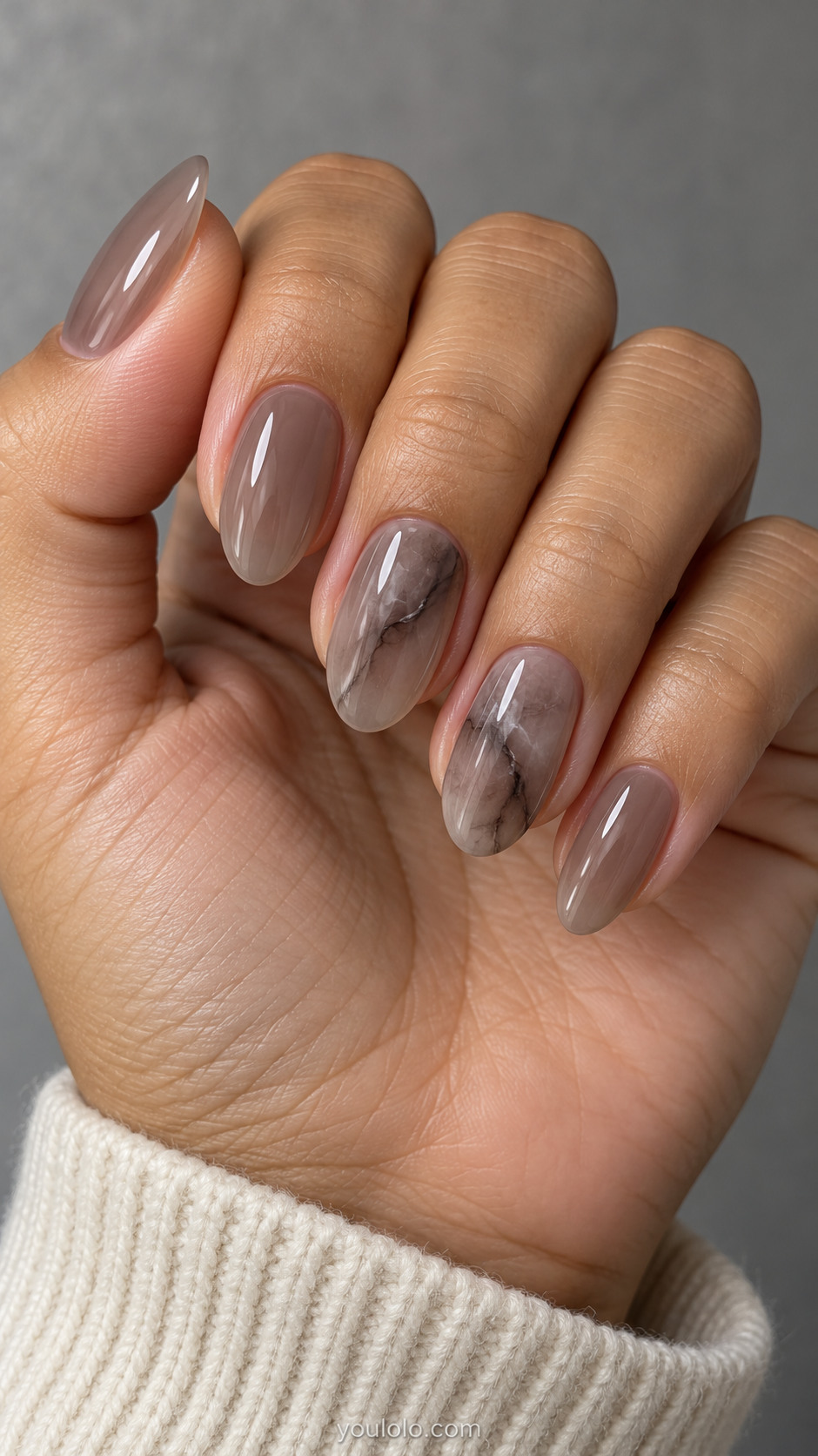 Medium oval nails: translucent smoky taupe jelly nails with wispy cloudy charcoal quartz veins on two accents, others plain translucent taupe.