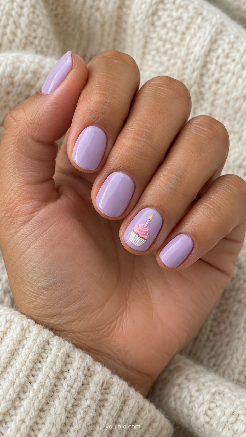 Short lilac nails with a pink cupcake and single candle on one accent nail