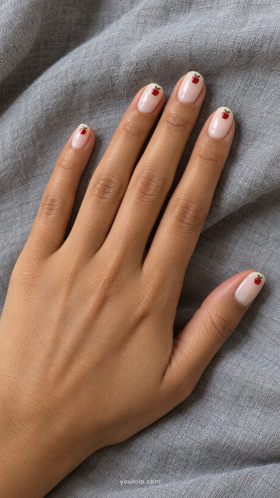 Short oval nails milky cream tiny red apples green stems placed at tips