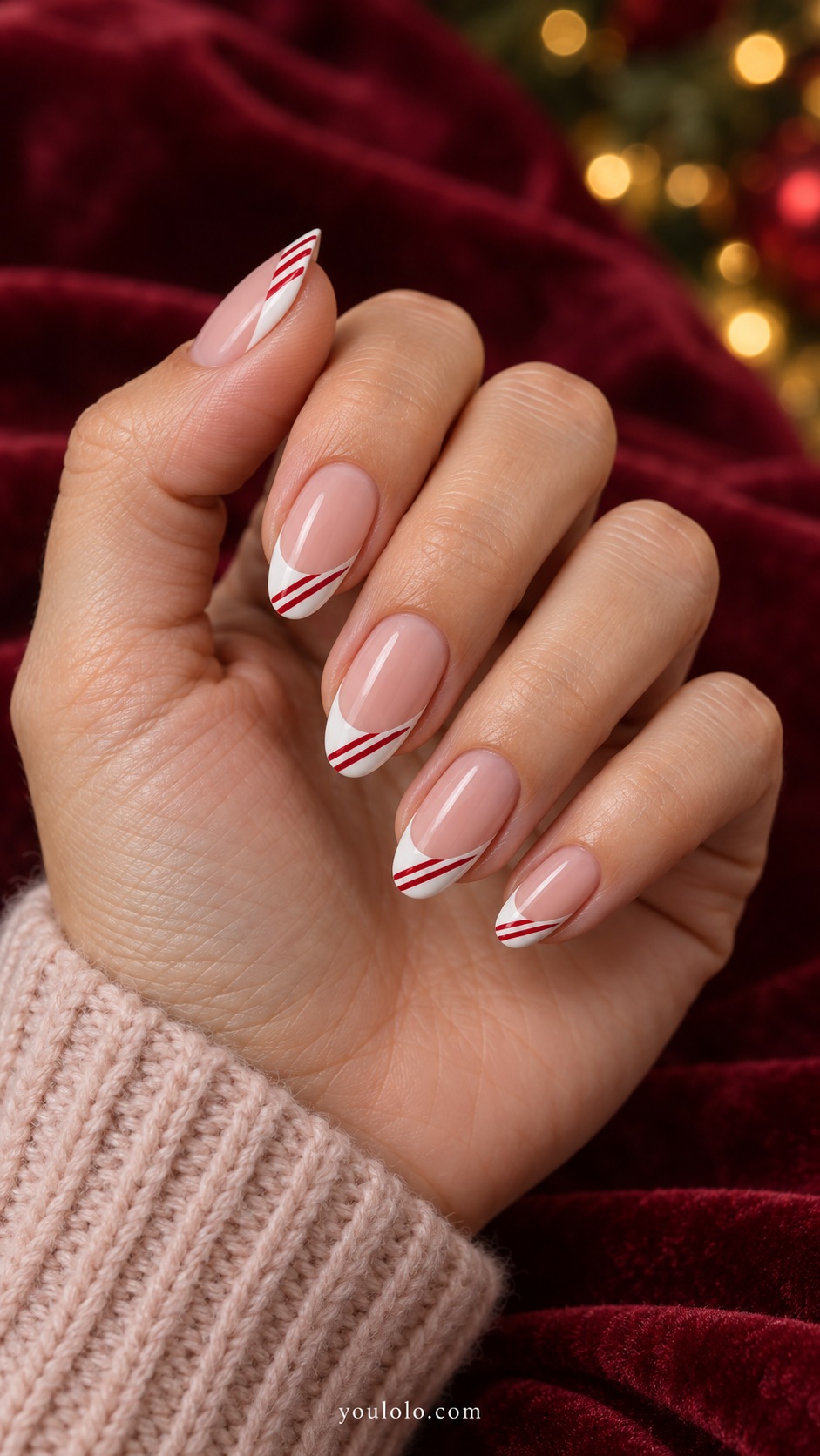 Medium almond nude pink nails white french tips with thin diagonal red stripes