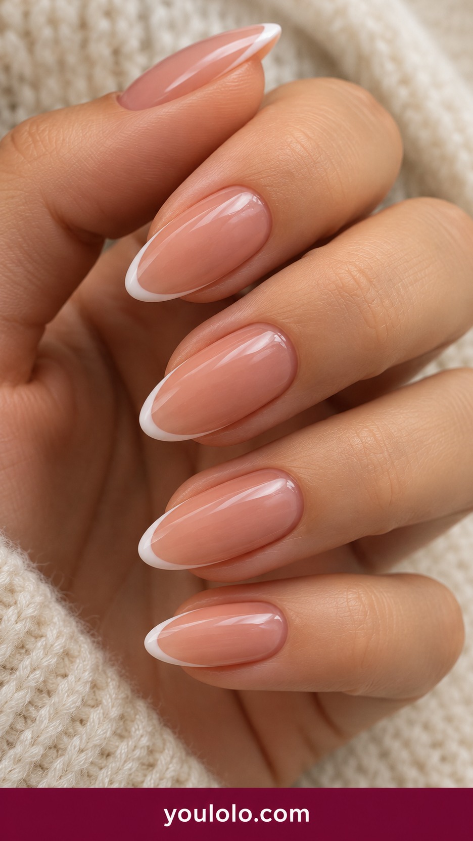 Medium oval nude pink nails with extremely thin classic white French tip no other art on a naturally curled young adult hand