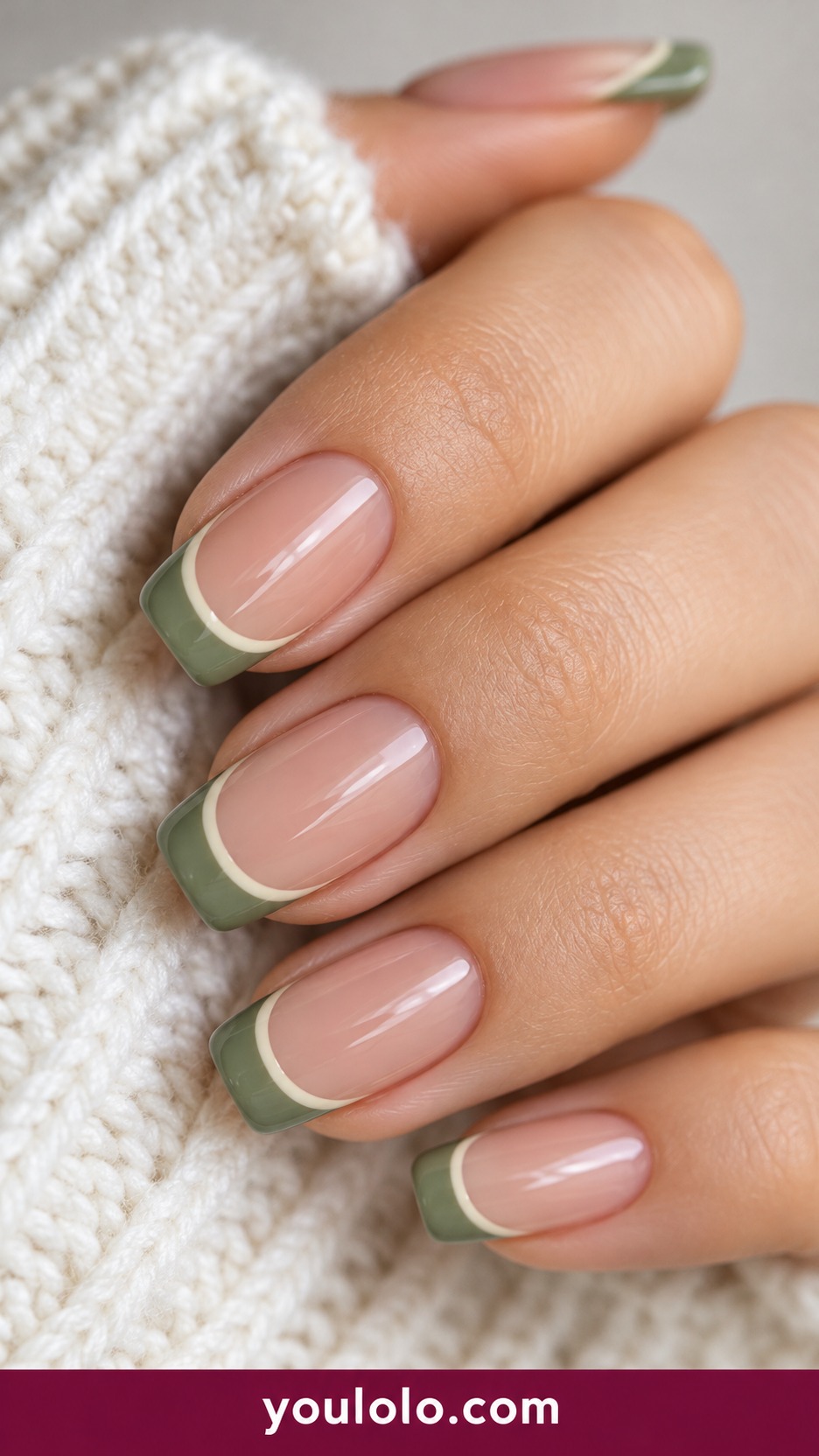 Short square sheer beige nails sage green French tips with very fine cream border on a naturally curled young adult hand