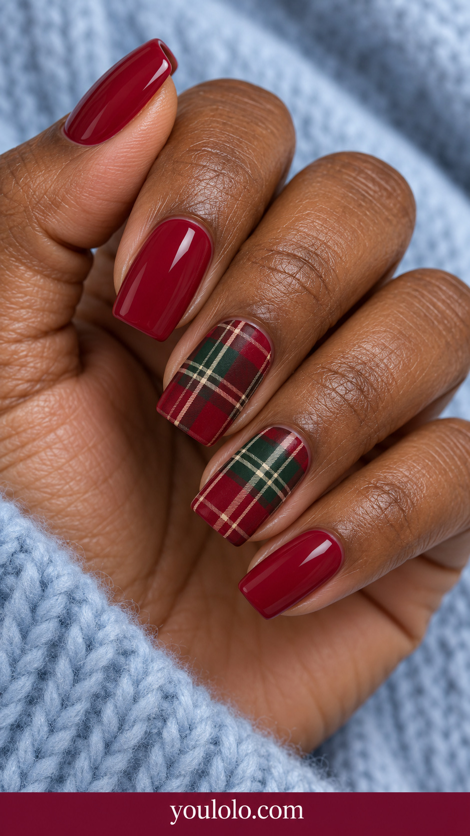 medium square scarlet nails, two accent nails with fine forest green and ivory tartan grid, rest plain scarlet glossy on a naturally relaxed adult hand