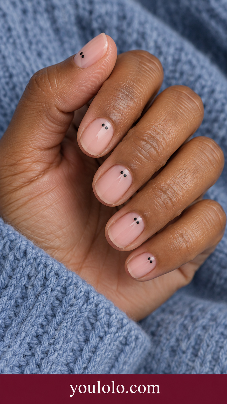 Double Ink Dots: short round sheer pink nails two tiny black dots side by side near base of each nail on a naturally posed adult hand