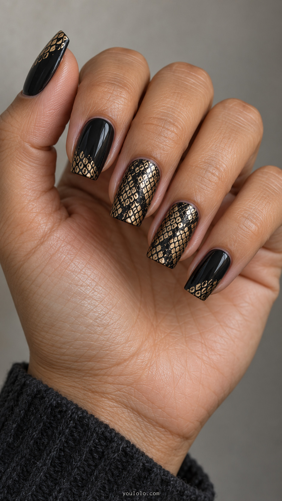 Black tapered square nails with gold snakeskin stamping and small scale-pattern tips