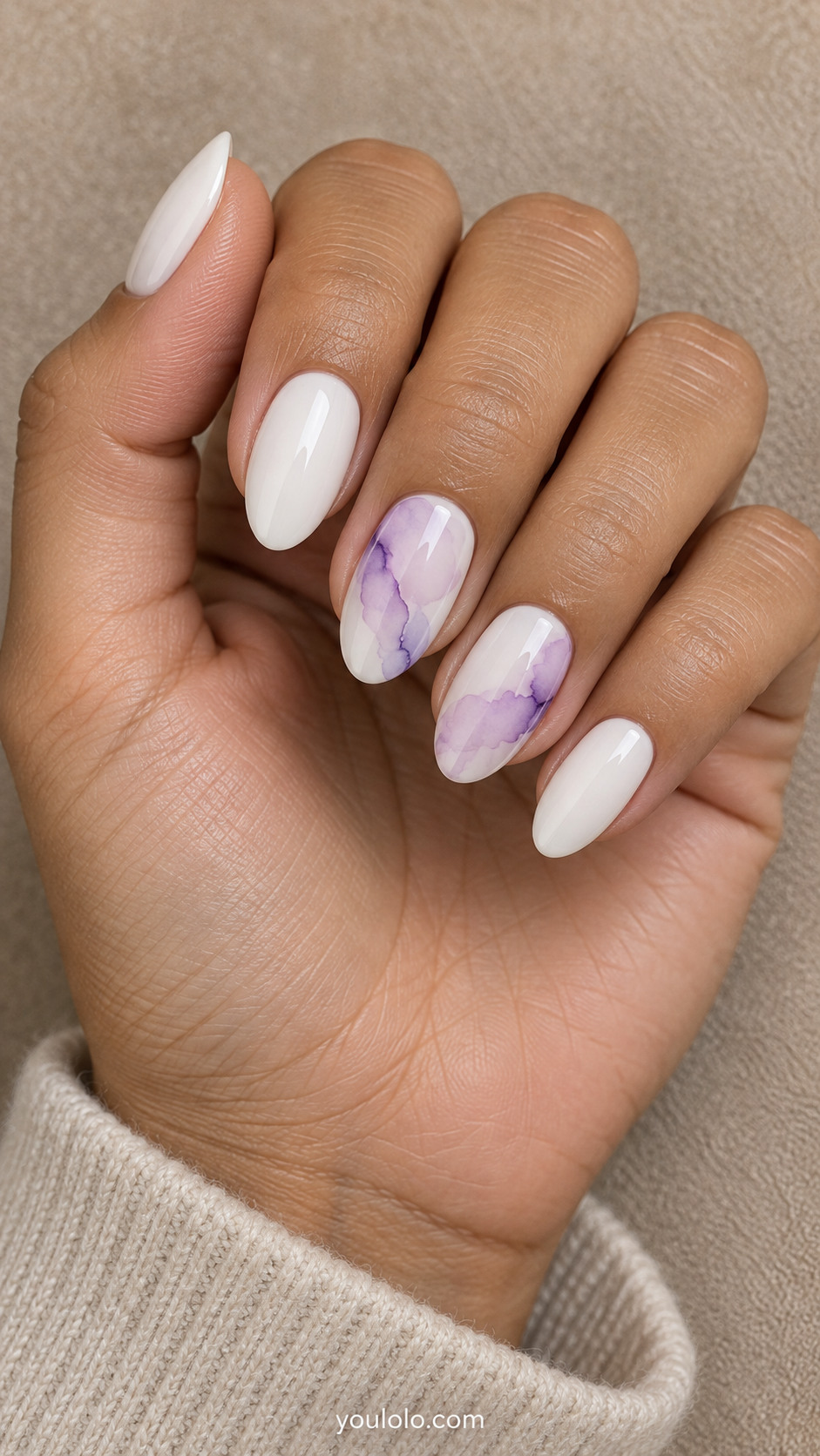 White almond nails with lilac watercolor washes on two accent nails