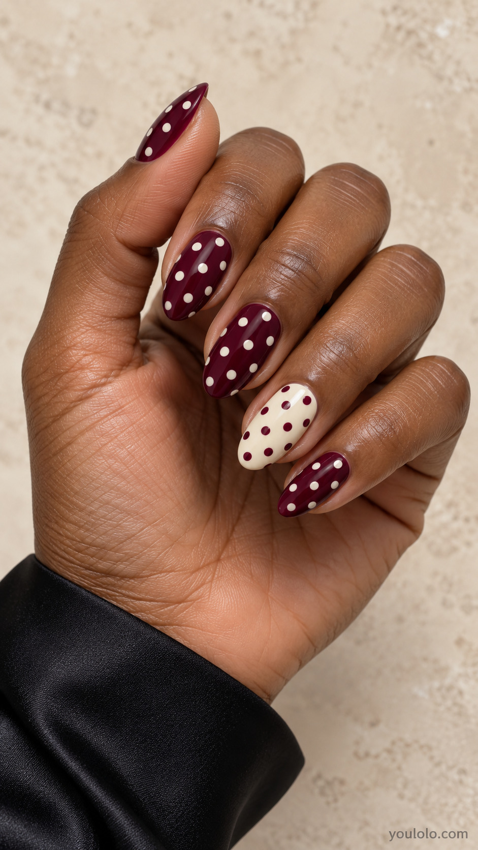 Medium almond nails: thumb index middle pinky dark burgundy with ivory medium dots; ring finger ivory with burgundy medium dots, same spacing.