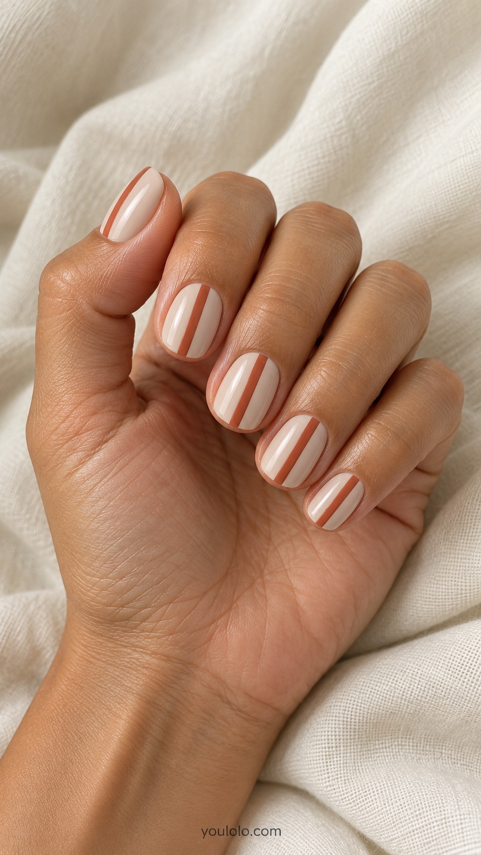 Short rounded square nails pale beige one straight narrow terracotta vertical stripe offset each nail