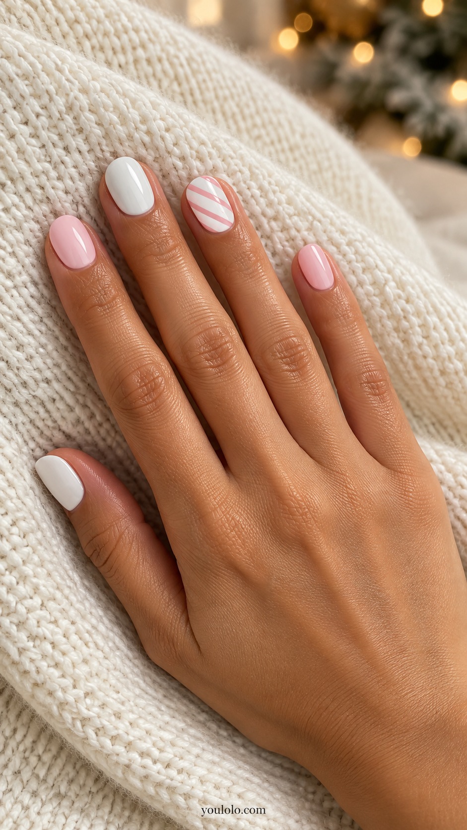 Short round alternating opaque white and pale pink nails one white nail with fine pink diagonal candy stripes