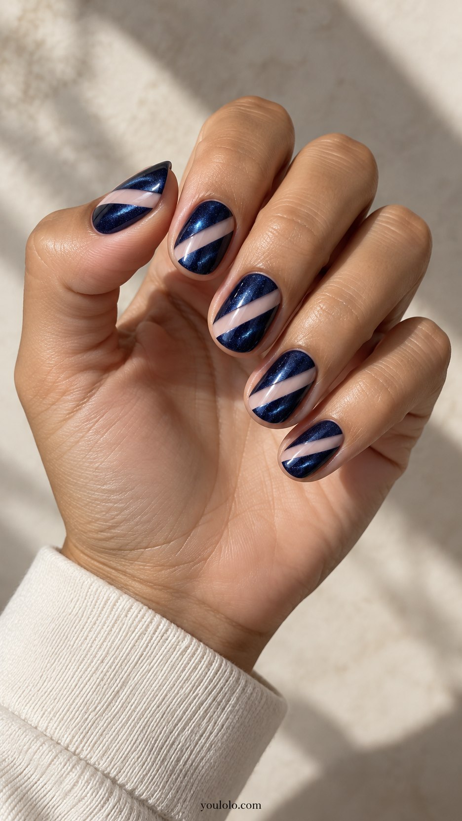 Midnight Velvet Negative-Space Diagonal: short rounded nails, midnight blue magnetic velvet diagonal panels separated by clean nude diagonal band