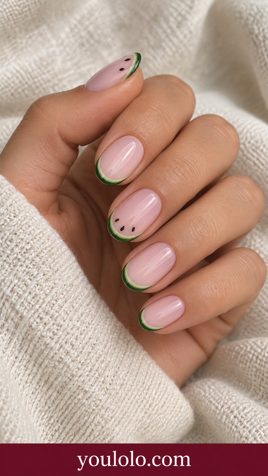 Tiny Watermelon Rind: short oval milky pink nails thin curved green watermelon rind edge with tiny dark seed dots on two accents on a naturally posed adult hand