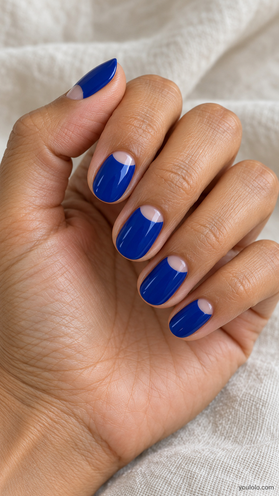 Short oval royal blue nails with nude half-moons near the cuticles