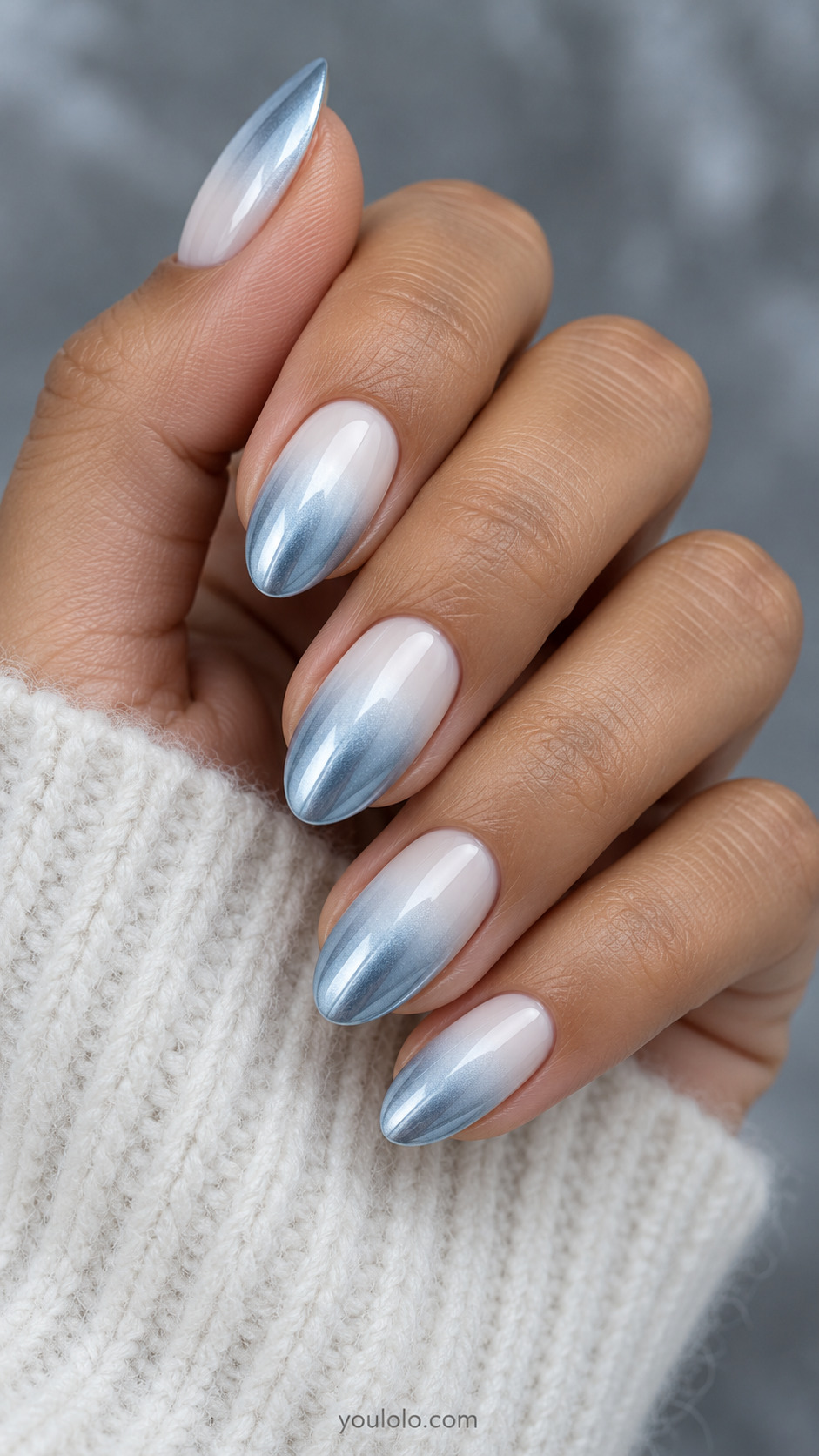 Milky white-to-ice-blue chrome ombre with a feathered transition on almond nails.