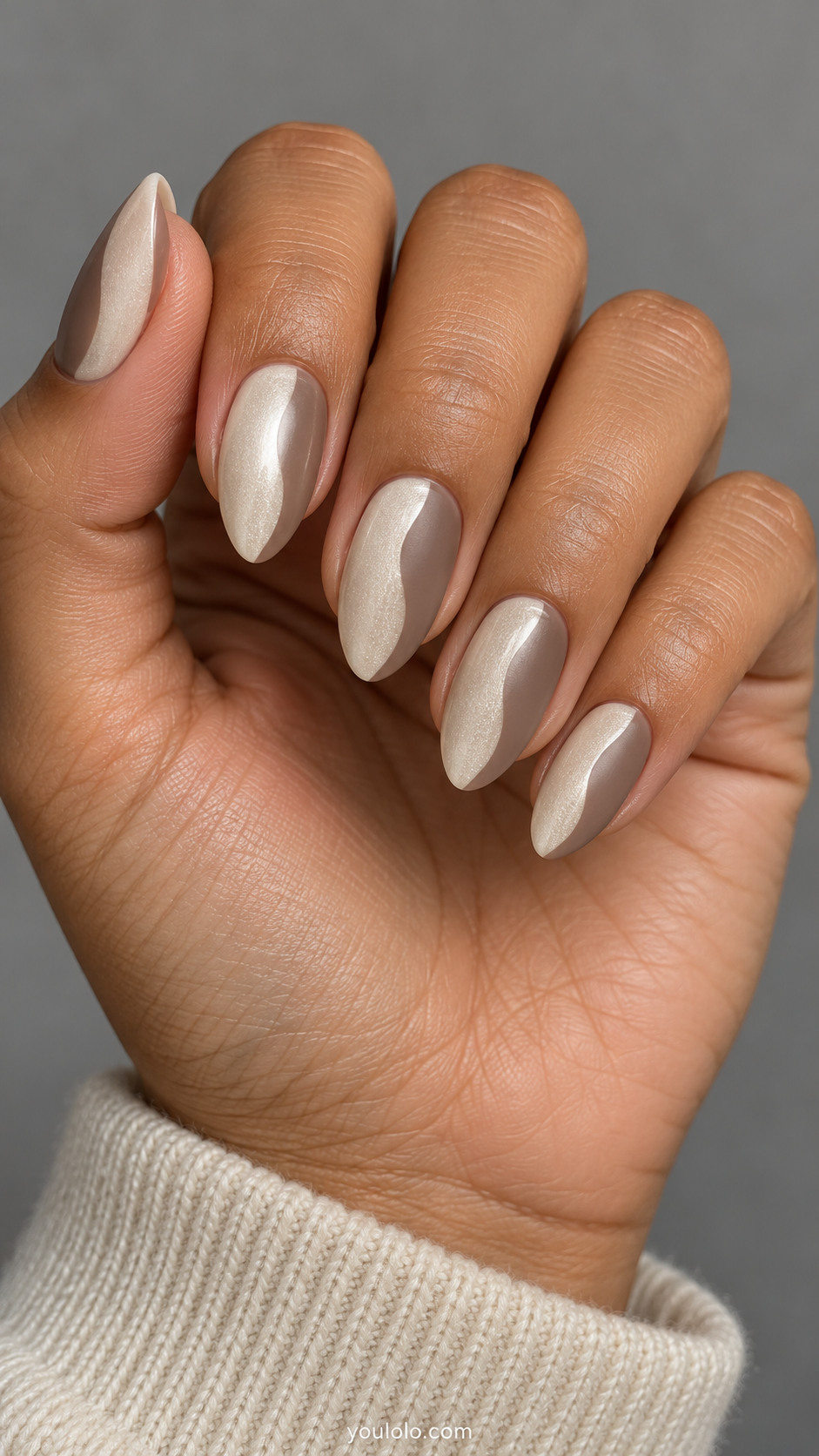 Medium almond nails: nails split vertically into pearly ivory and smooth taupe with a gently curved border, no outline.