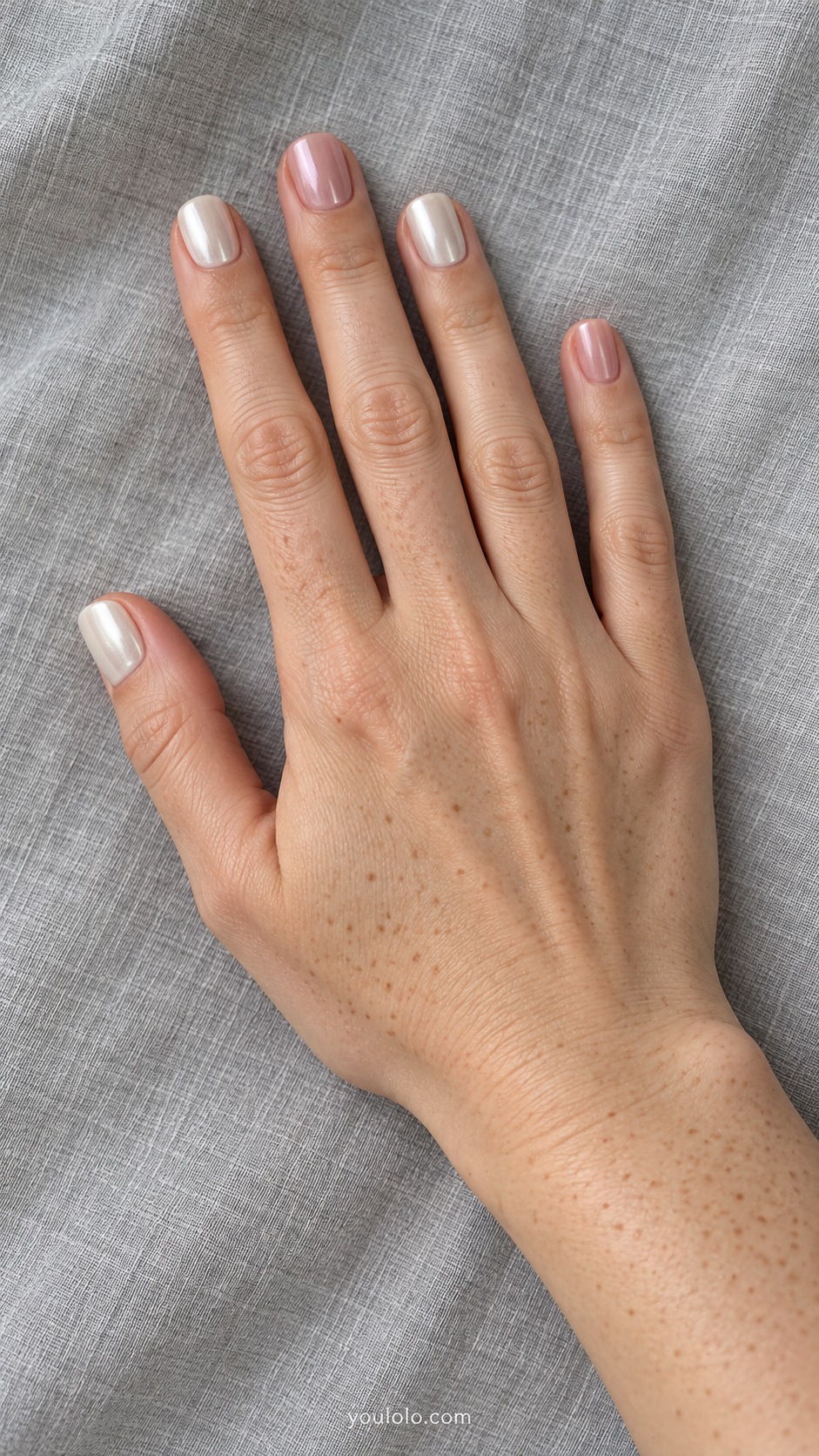 Short square nails alternating opaque ivory pearl and translucent neutral pink pearl, no art