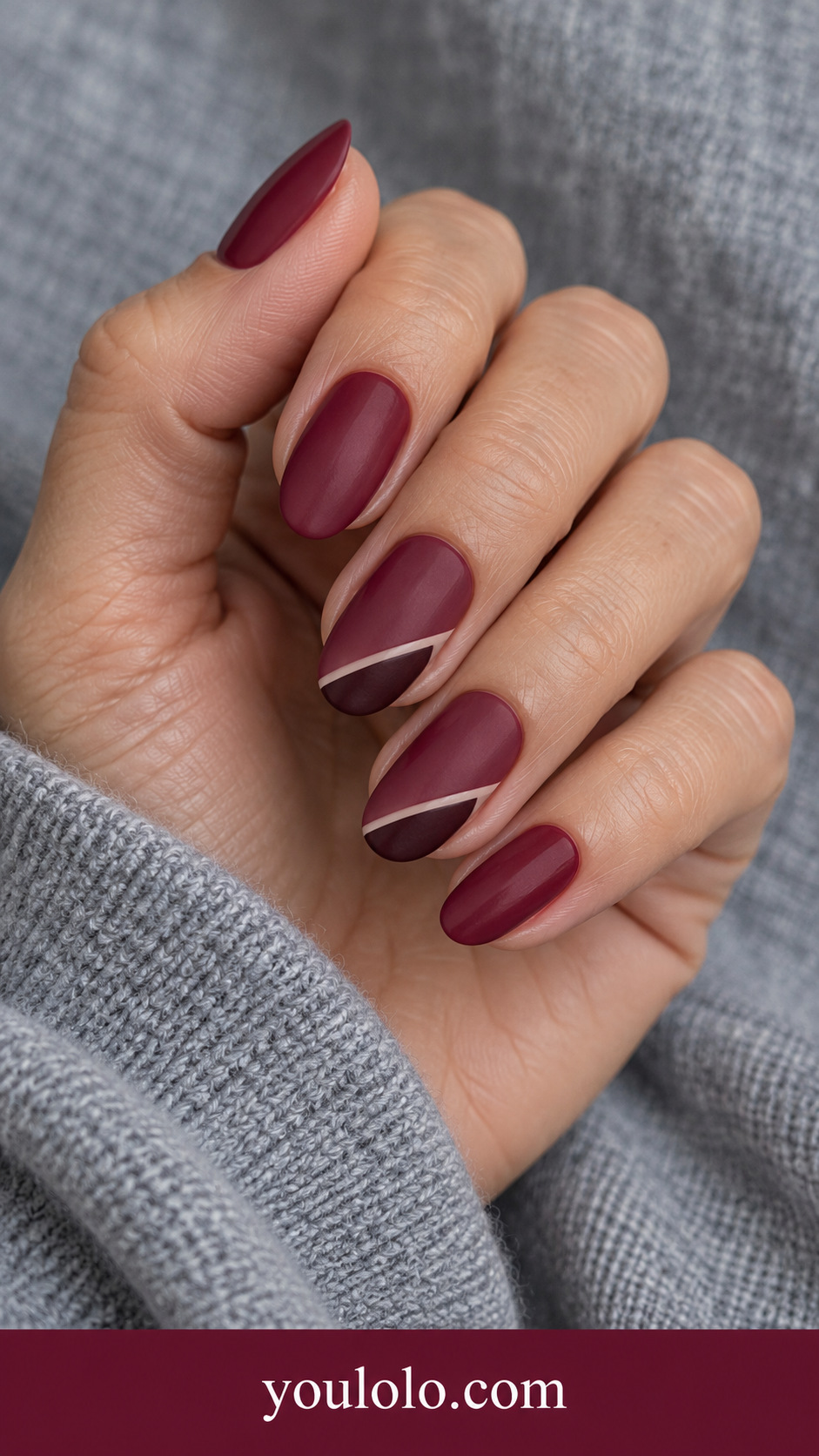 Maroon Velvet Corner: medium almond satin maroon nails two accents small deeper matte burgundy triangular corners with thin nude separator on a naturally posed adult hand