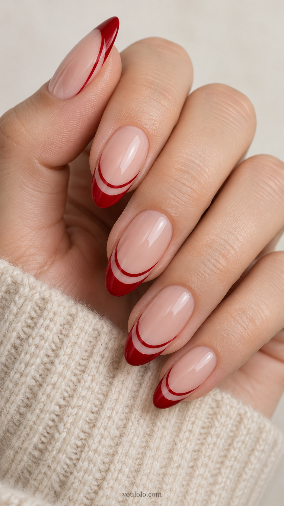 medium almond nude nails, red tip edge and second parallel fine curved red line below with clear nude gap on a naturally gathered hand