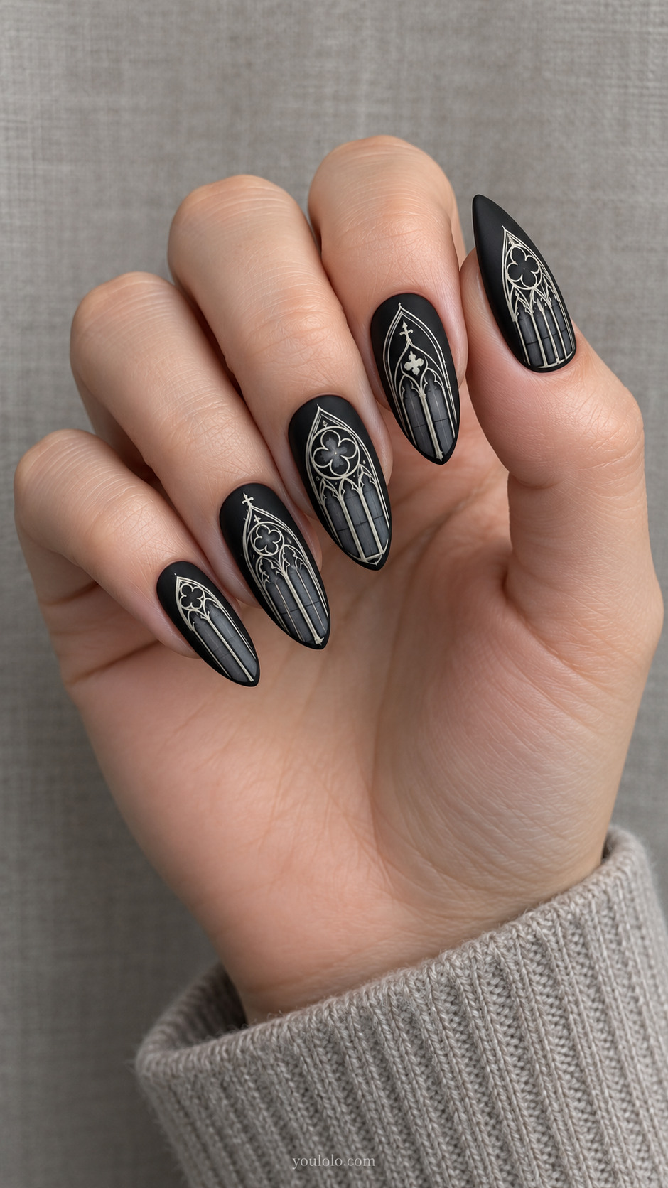 Long almond matte black nails with slim ivory gothic arched window outlines and pale gray inner tracery, vary window pattern per nail