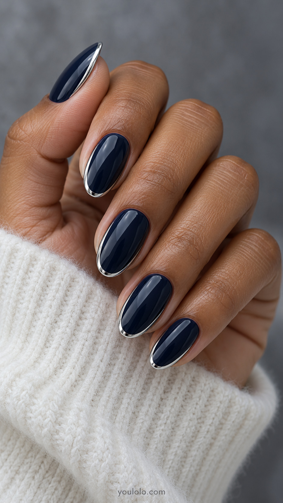 Glossy navy oval nails outlined with a thin silver chrome edge.