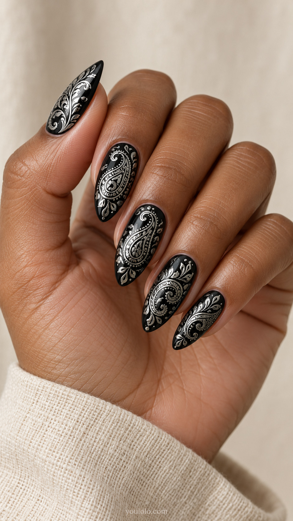 Long almond black nails intricate flat metallic silver paisley curls with tiny hollow teardrops, alternating large small motifs, refined ornamental engraving