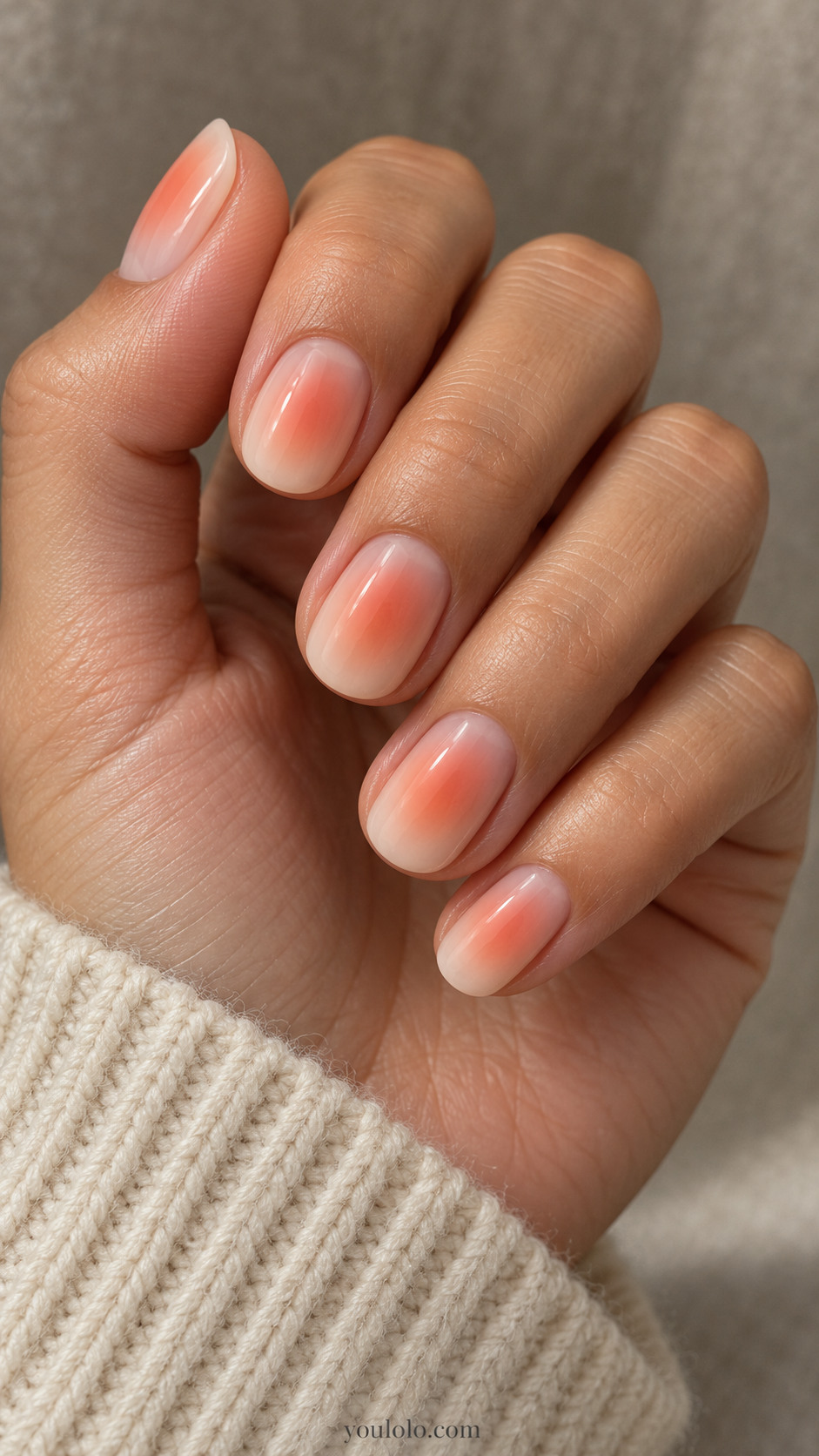 Short nude nails with a softly diffused peach center glow