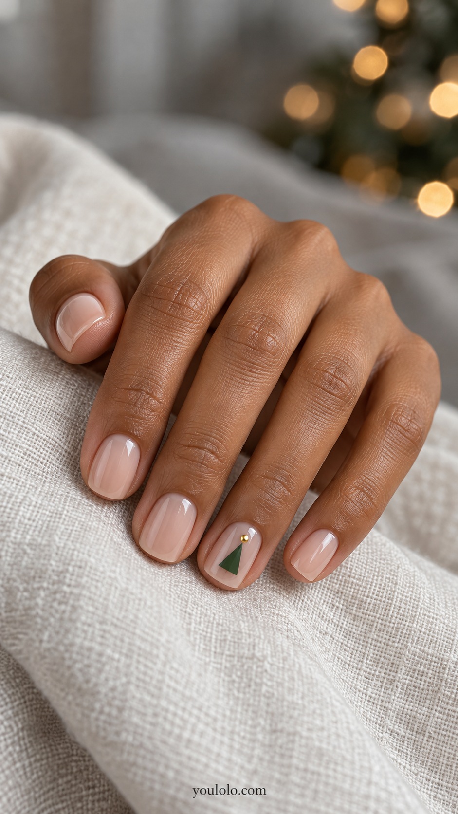 Short squoval sheer beige nails one ring nail flat green triangle with a tiny gold dot above, other nails plain sheer beige