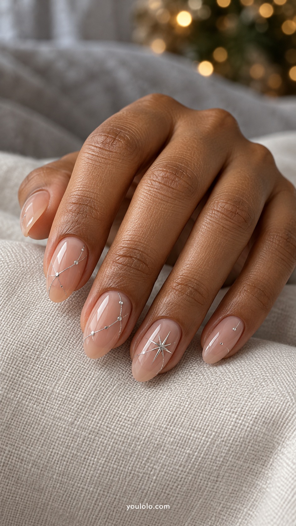 Medium almond sheer nude nails tiny silver dots joined by fine silver lines on two nails with one four point star