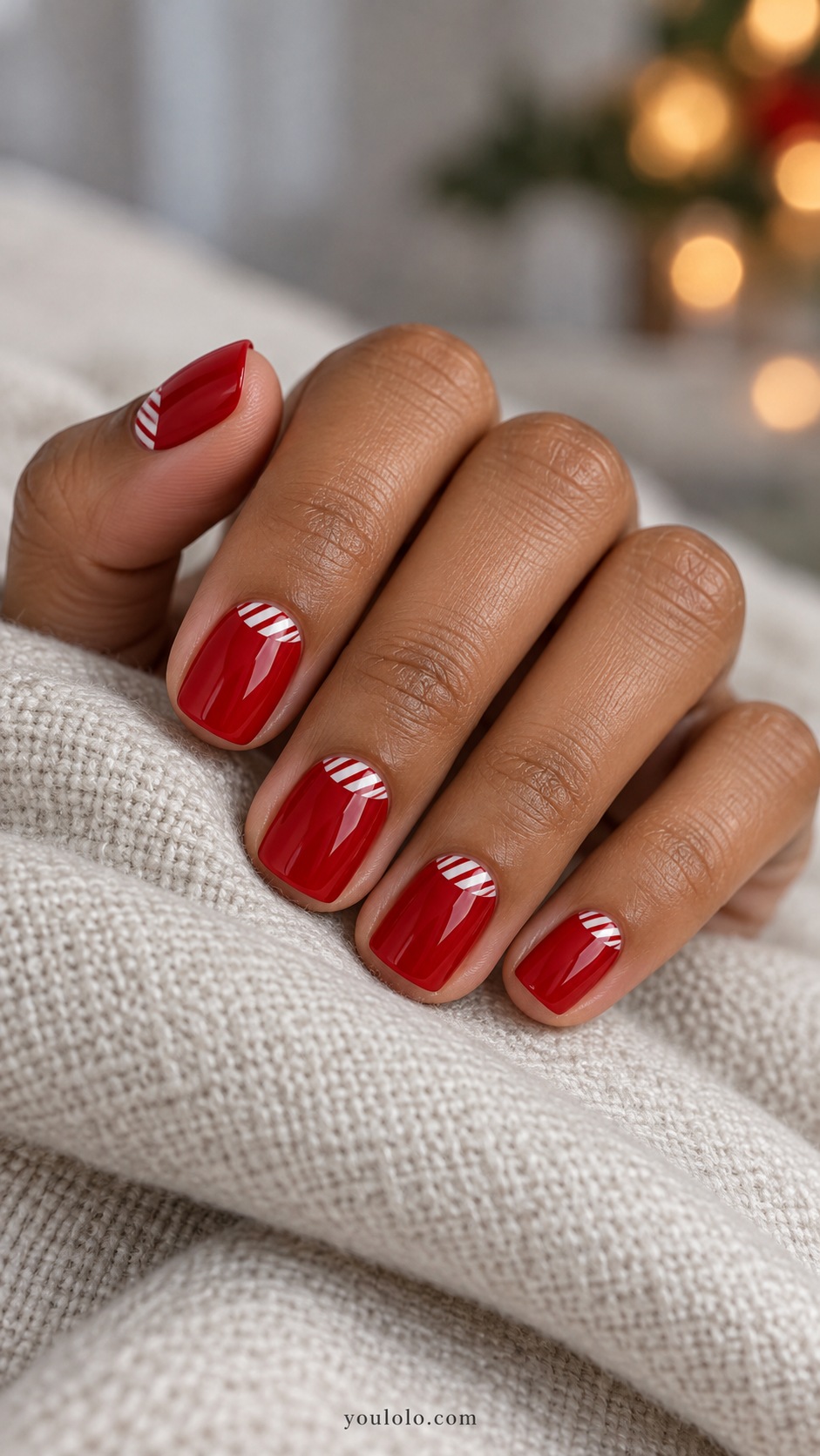Short squoval red nails tiny white half moons with fine red diagonal stripes within white areas