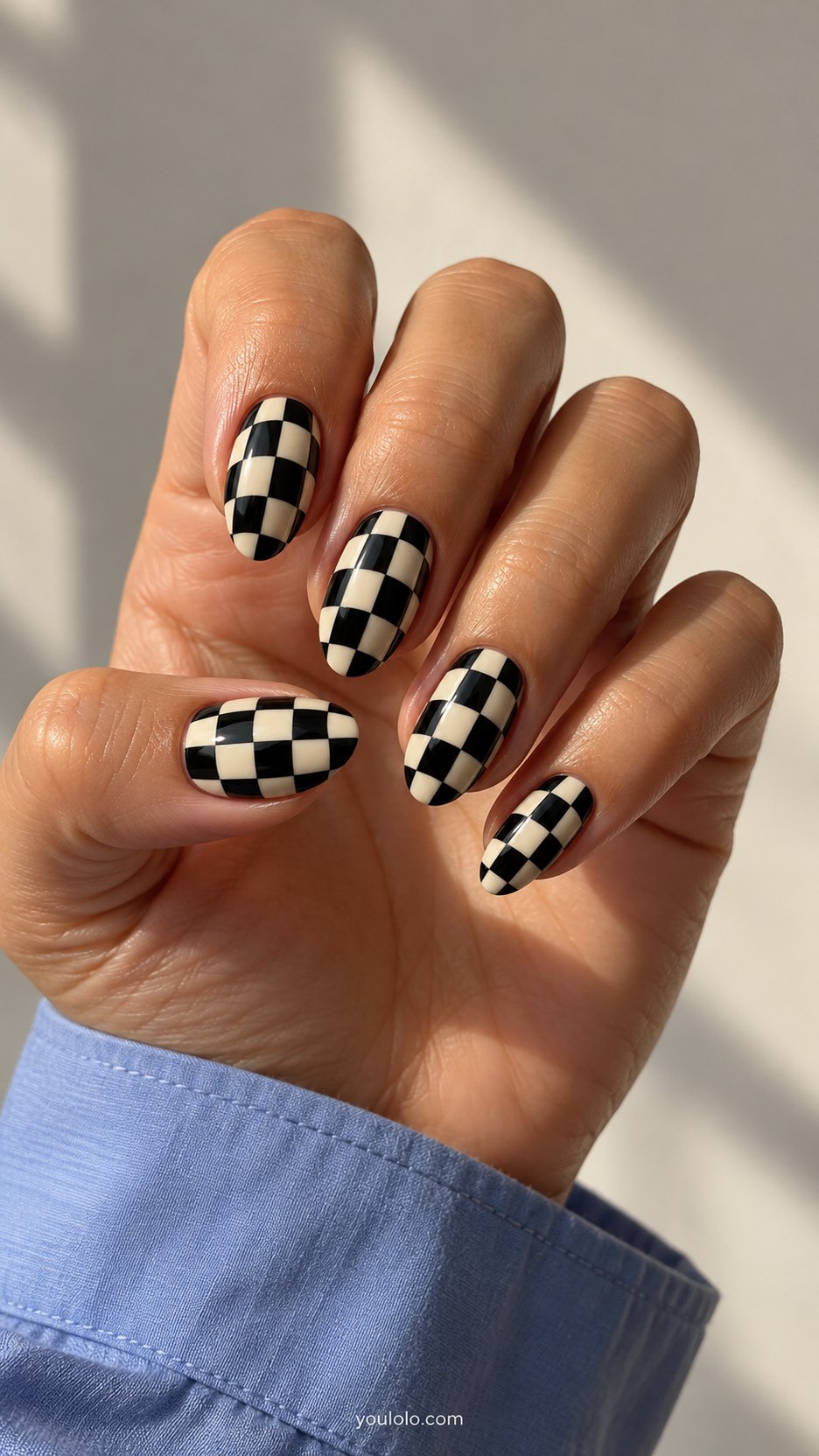 Bent Checkerboard: medium almond nails, black cream checker grid painted curved to imply central bulge, flat surface