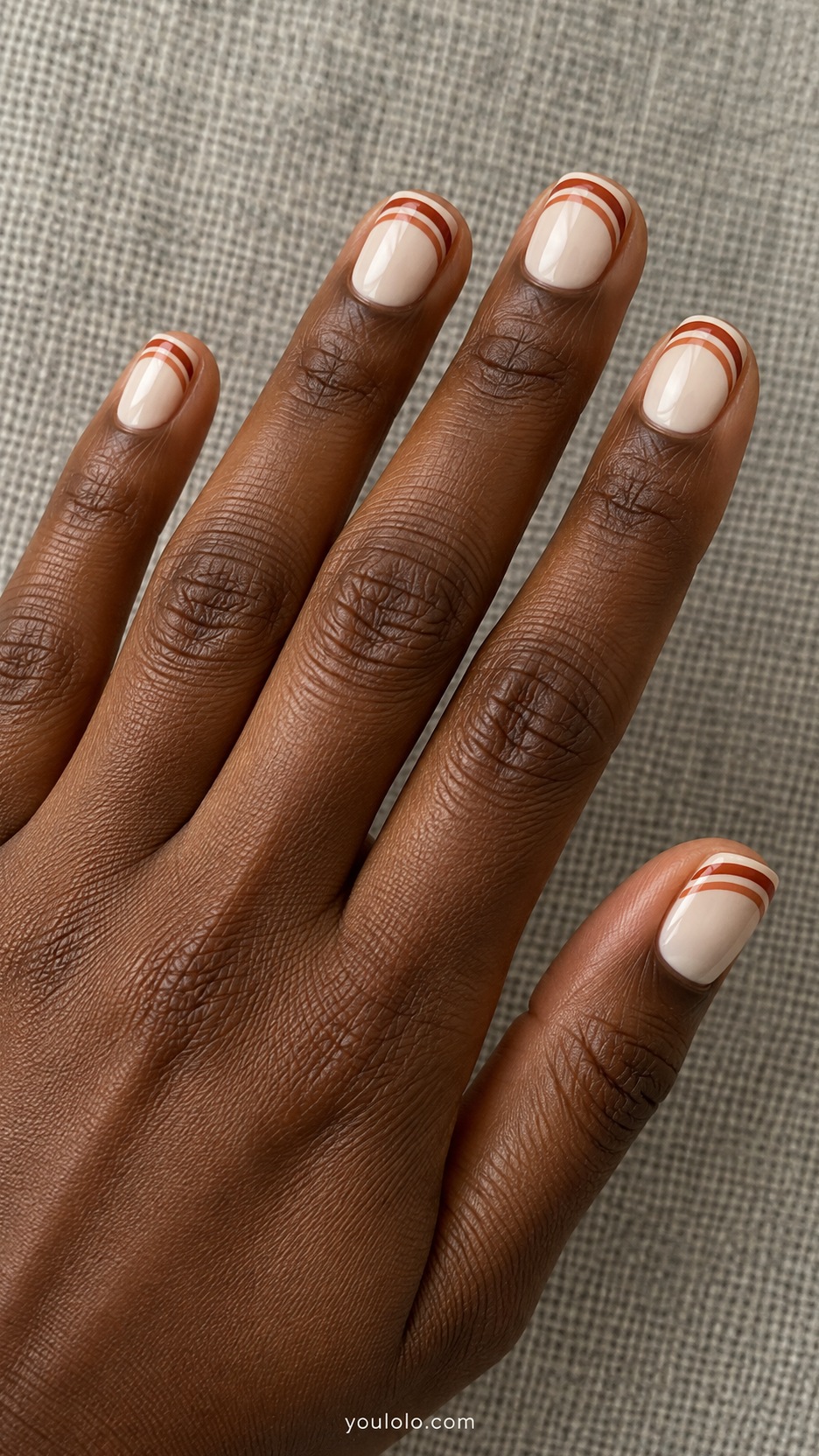 Short Artsy Nails: Retro Orange Arches manicure on a naturally posed hand