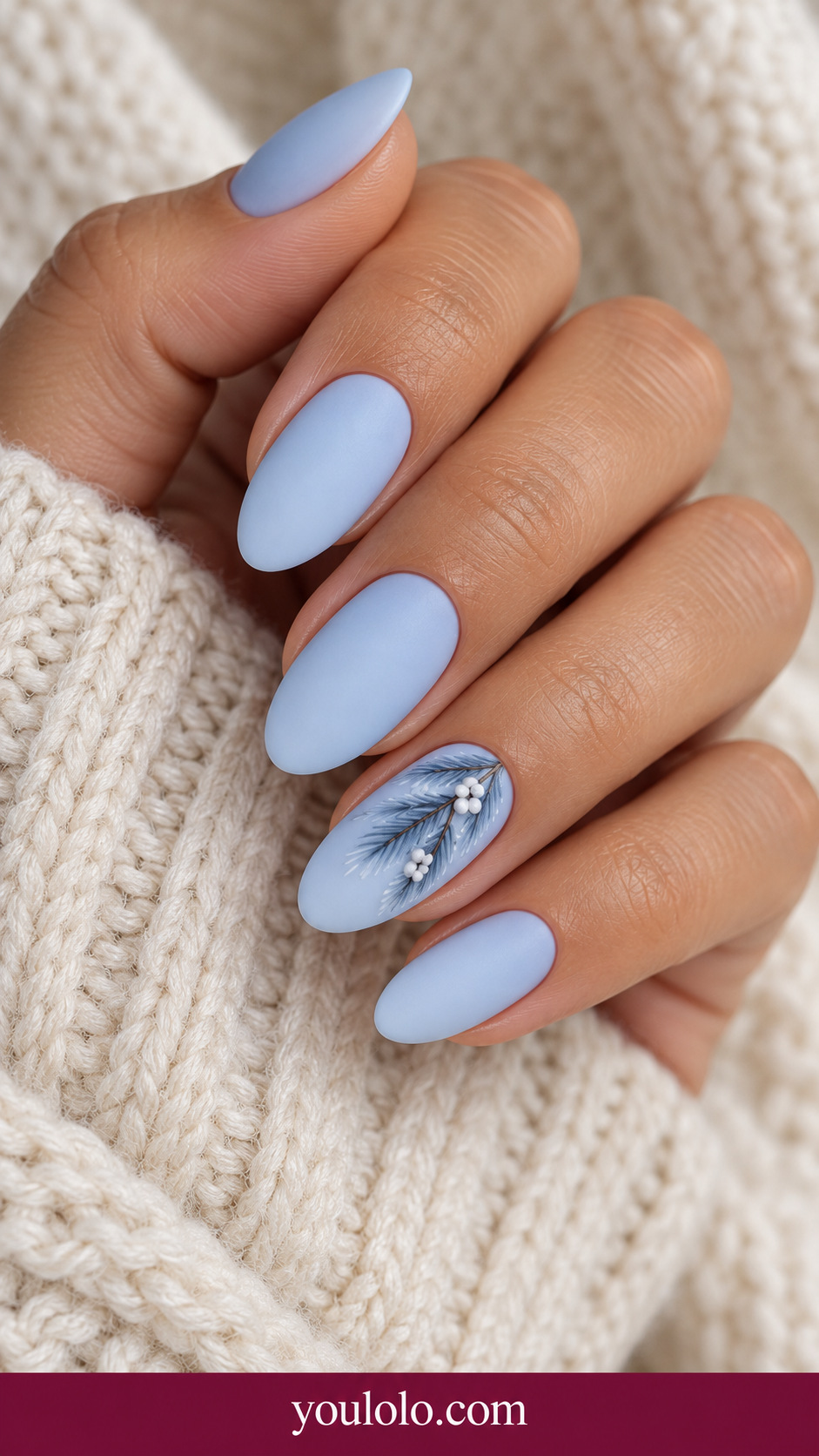 medium oval icy blue cream nails one accent fine darker blue pine branch with miniature white berry dots, others plain ice blue on a naturally relaxed adult hand