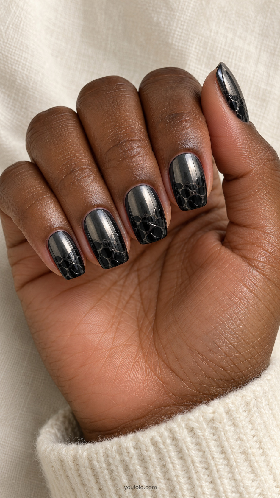 Medium squoval nails dark gunmetal chrome base with irregular soft black blooming gel cells across the lower half, upper half uninterrupted dark mirror
