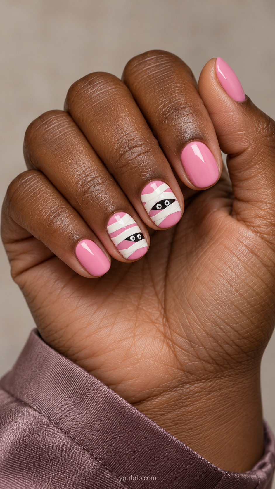 Bubblegum pink oval nails with ivory mummy bands and peeking eyes