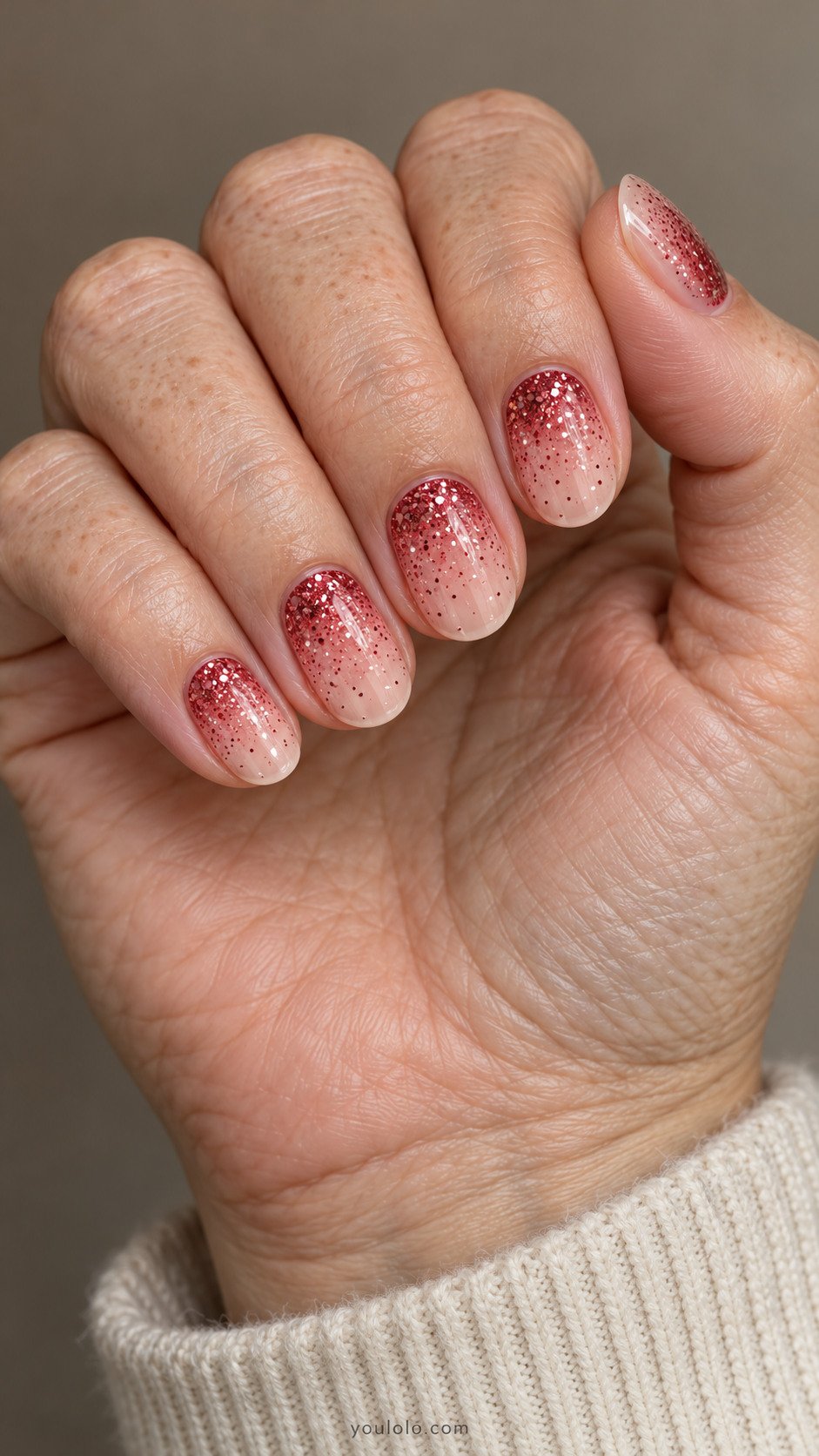 Short oval nails with crimson glitter fading from the cuticles