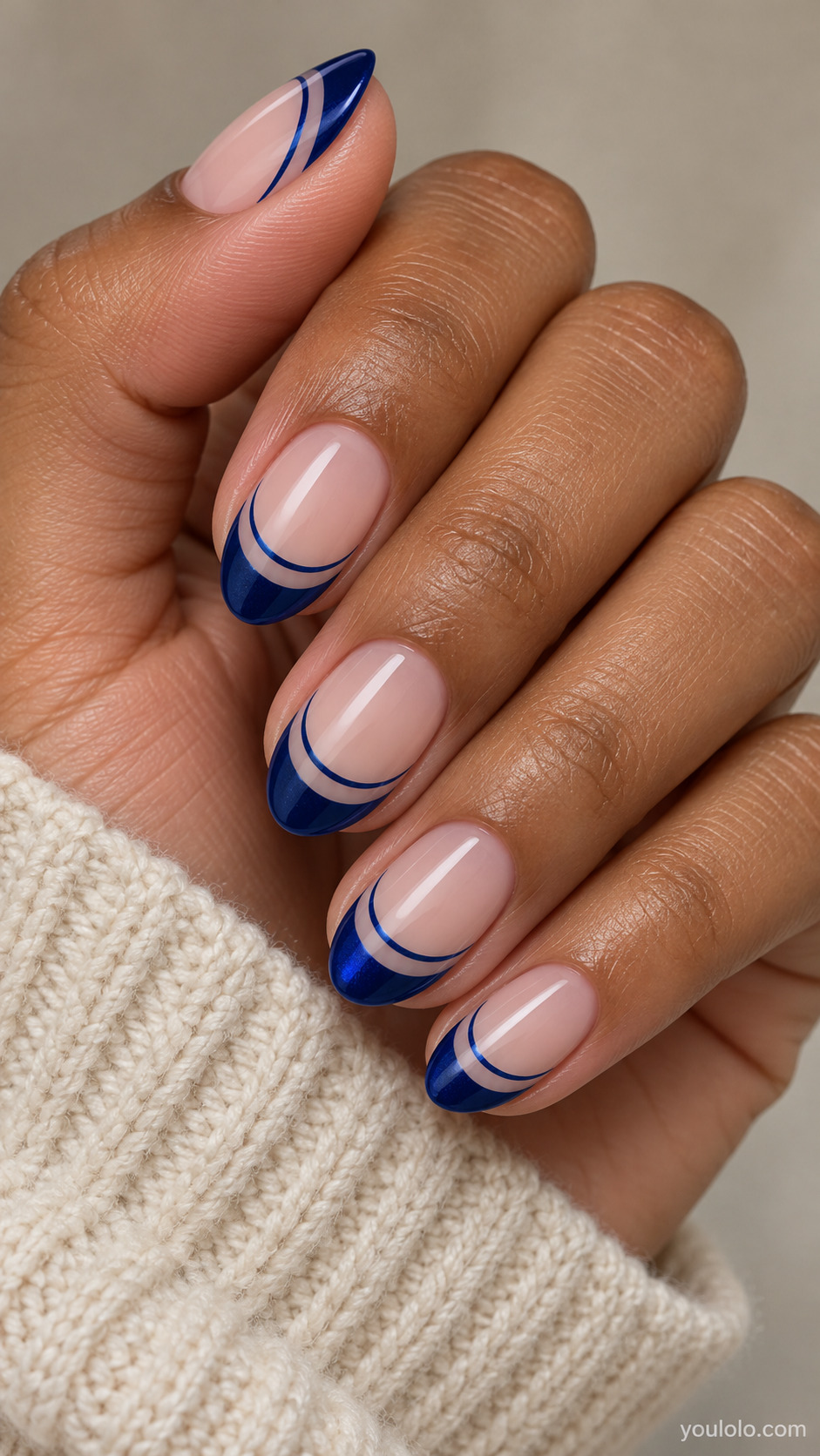 Double Sapphire French Arcs on a softly gathered feminine hand with detailed sapphire blue manicure