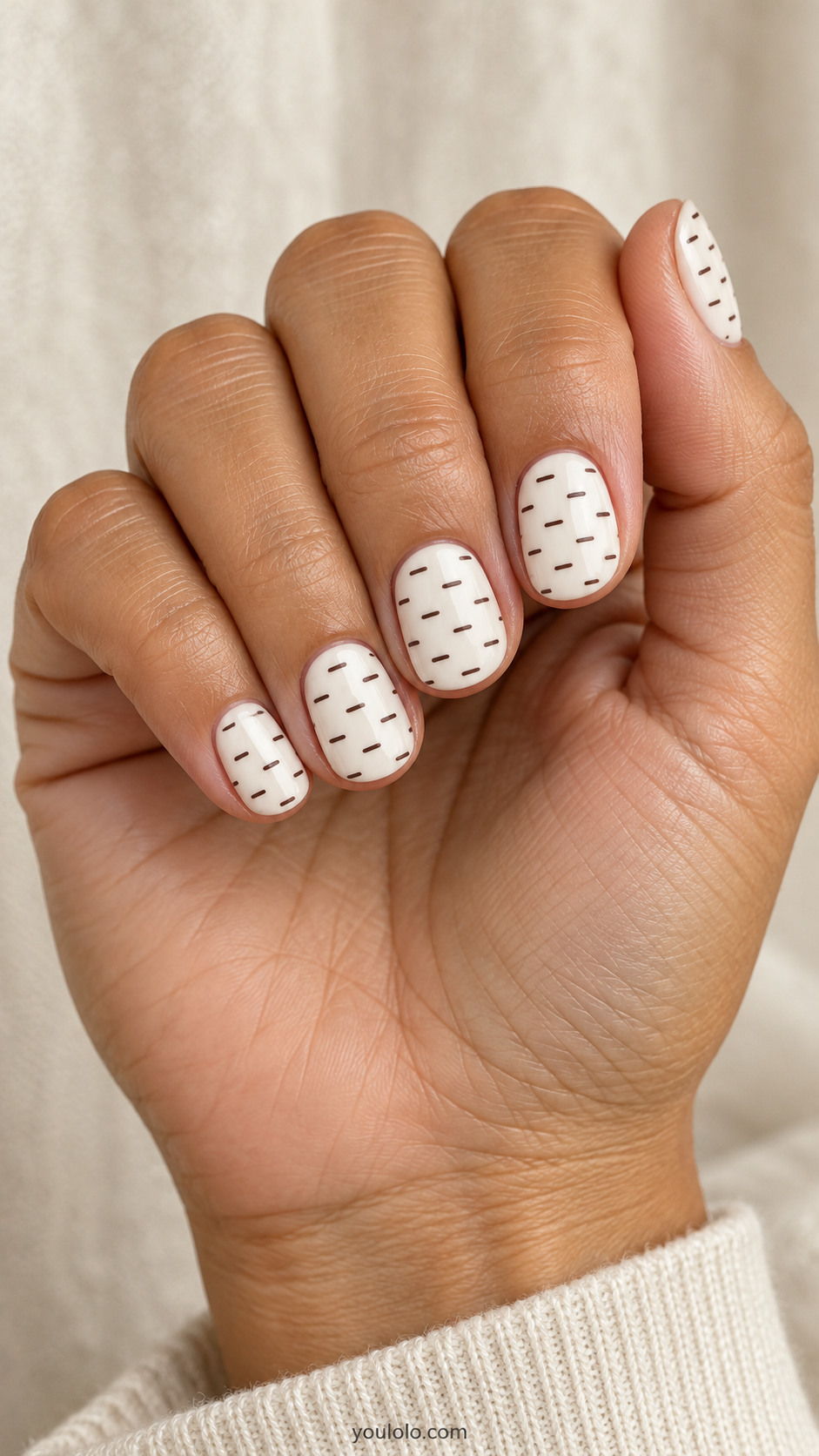 Short ivory nails with evenly spaced tiny espresso dashes